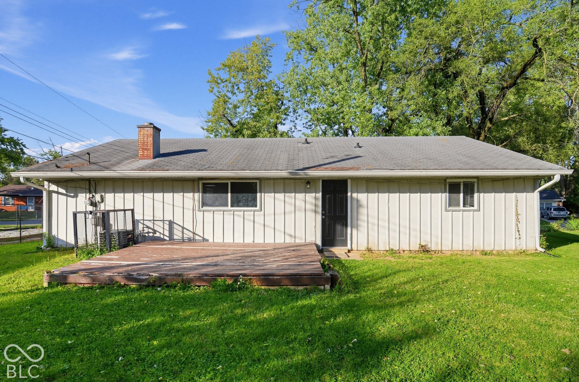 Rear exterior with siding, a prominent deck, and a shingled roof