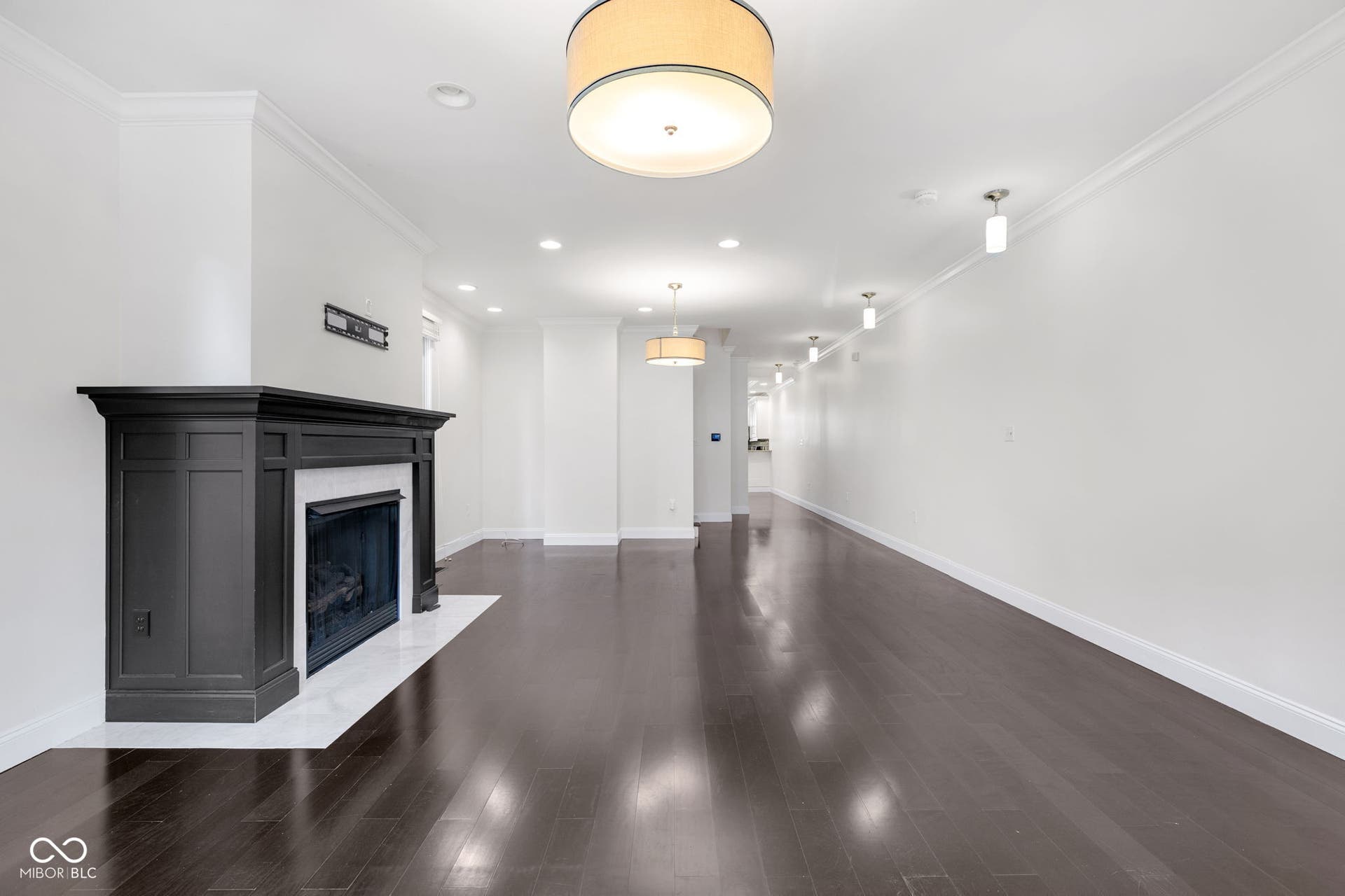Freshly painted (7/2025) living room featuring crown molding, wood finished floors, a fireplace with flush hearth, and recessed lighting