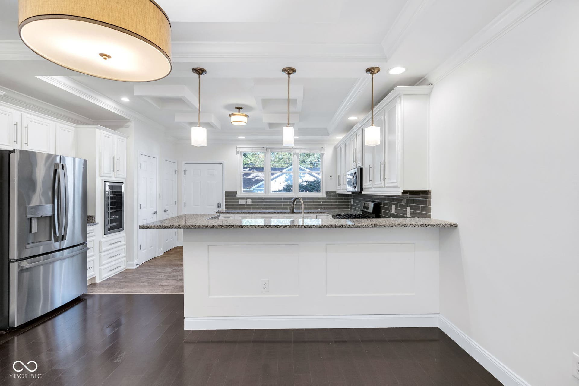 Kitchen & dining area - freshly painted (7/2025) featuring hardwood floors, ample cabinet space, stone countertops and stainless appliances.