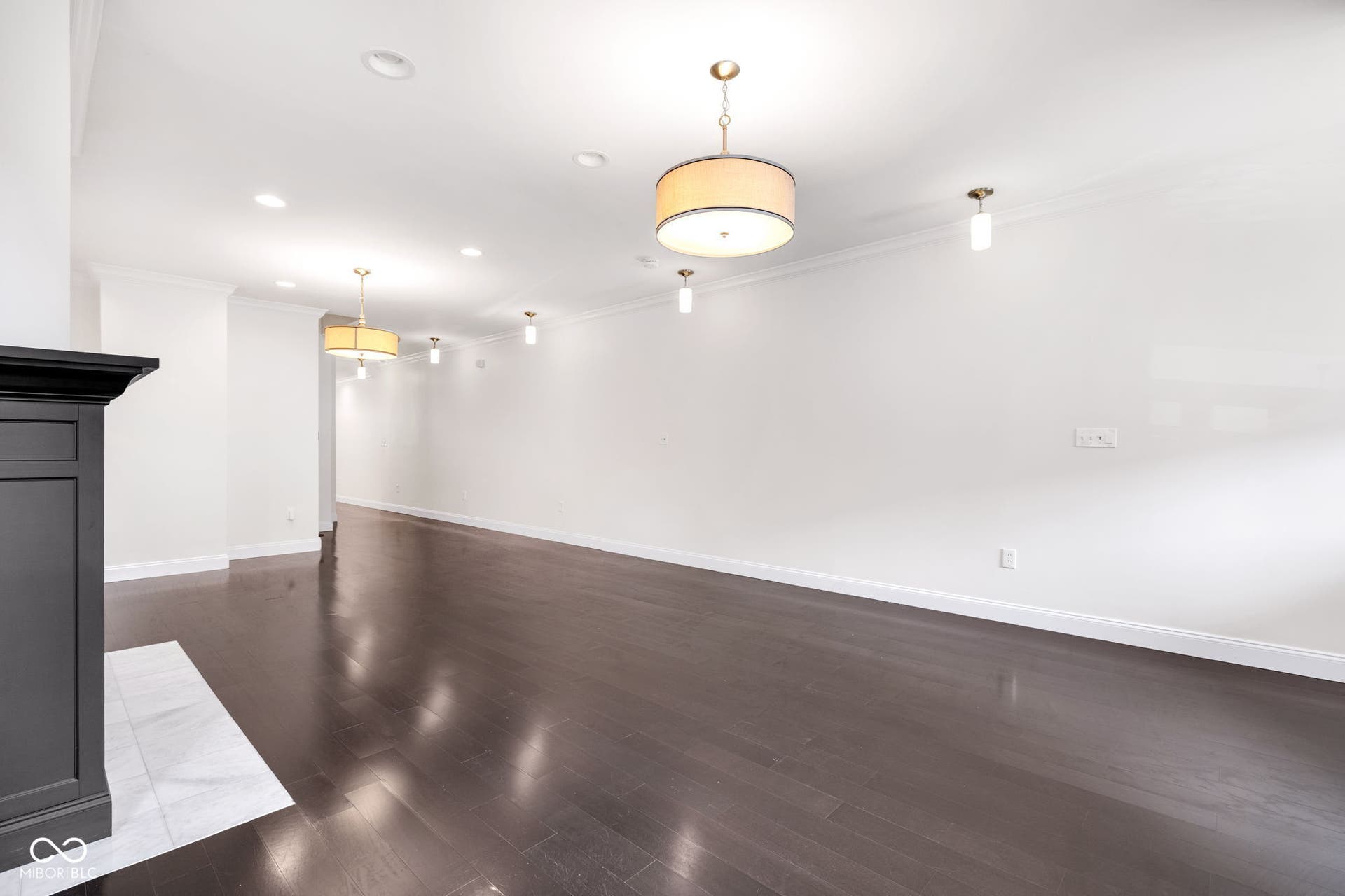 Freshly painted (7/2025) living room featuring crown molding, wood finished floors, a fireplace with flush hearth, and recessed lighting
