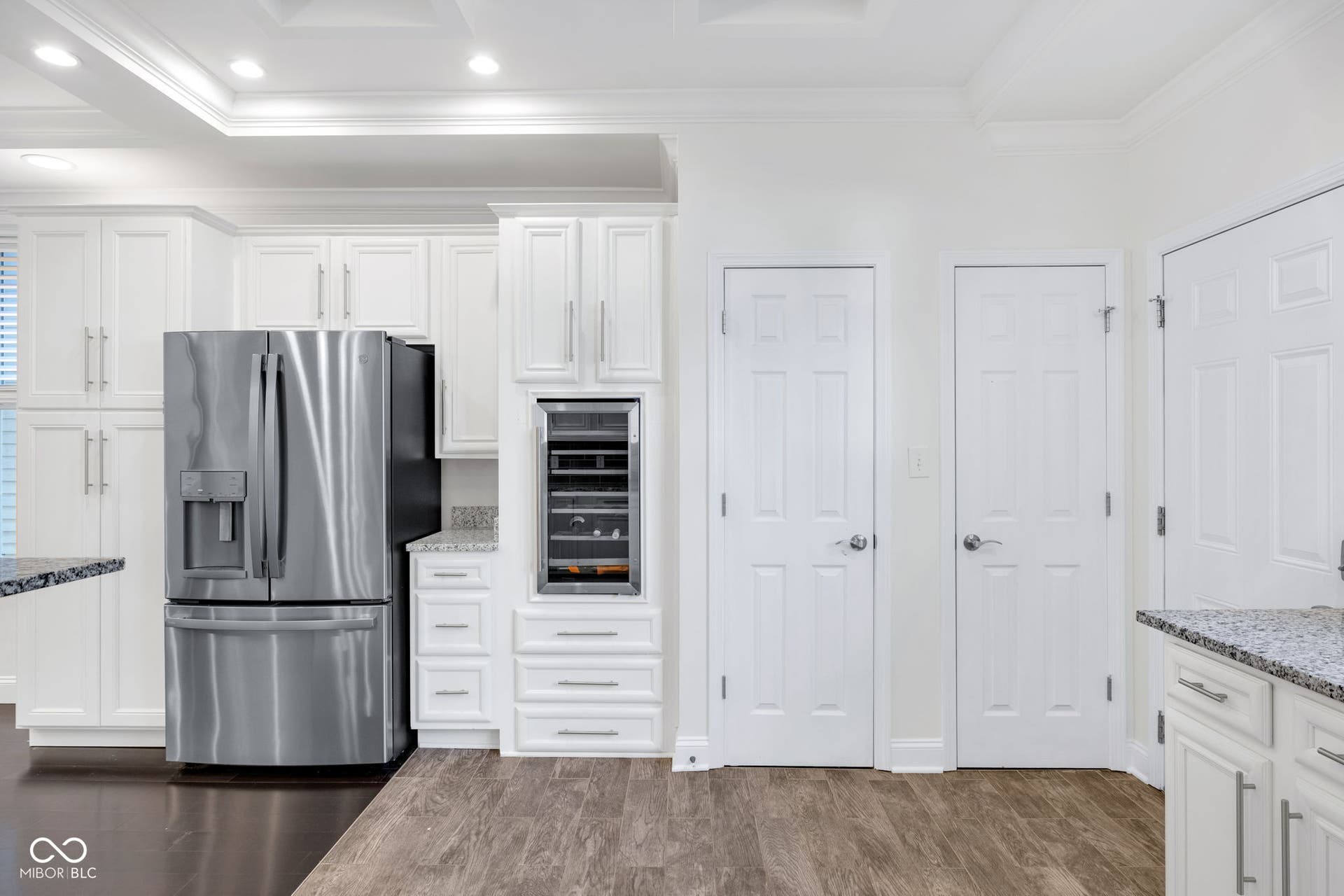 Kitchen & dining area - freshly painted (7/2025) featuring hardwood floors, ample cabinet space, stone countertops and stainless appliances.