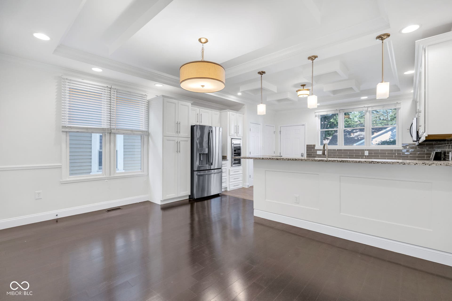 Kitchen & dining area - freshly painted (7/2025) featuring hardwood floors, ample cabinet space, stone countertops and stainless appliances.