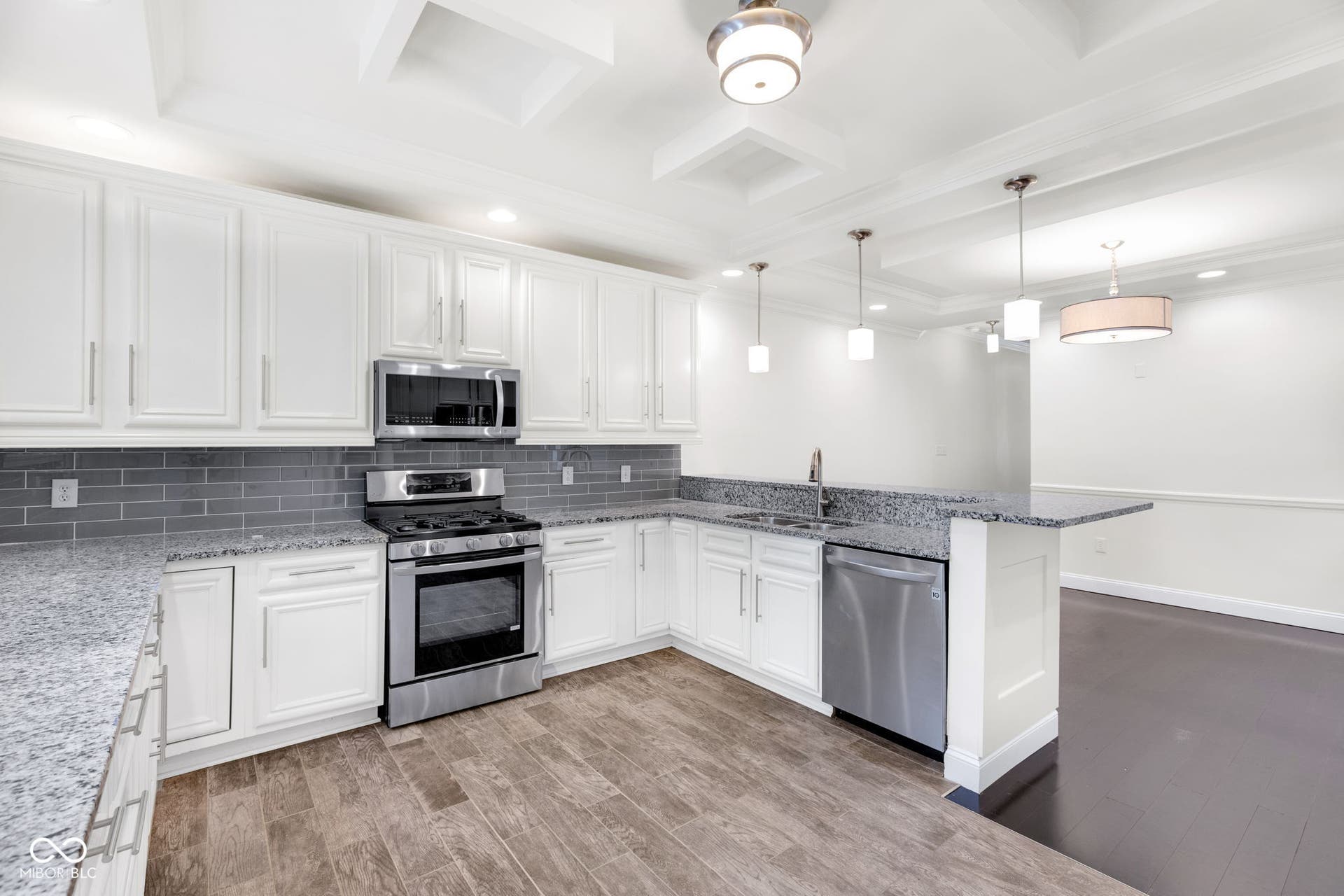 Kitchen & dining area - freshly painted (7/2025) featuring hardwood floors, ample cabinet space, stone countertops and stainless appliances.