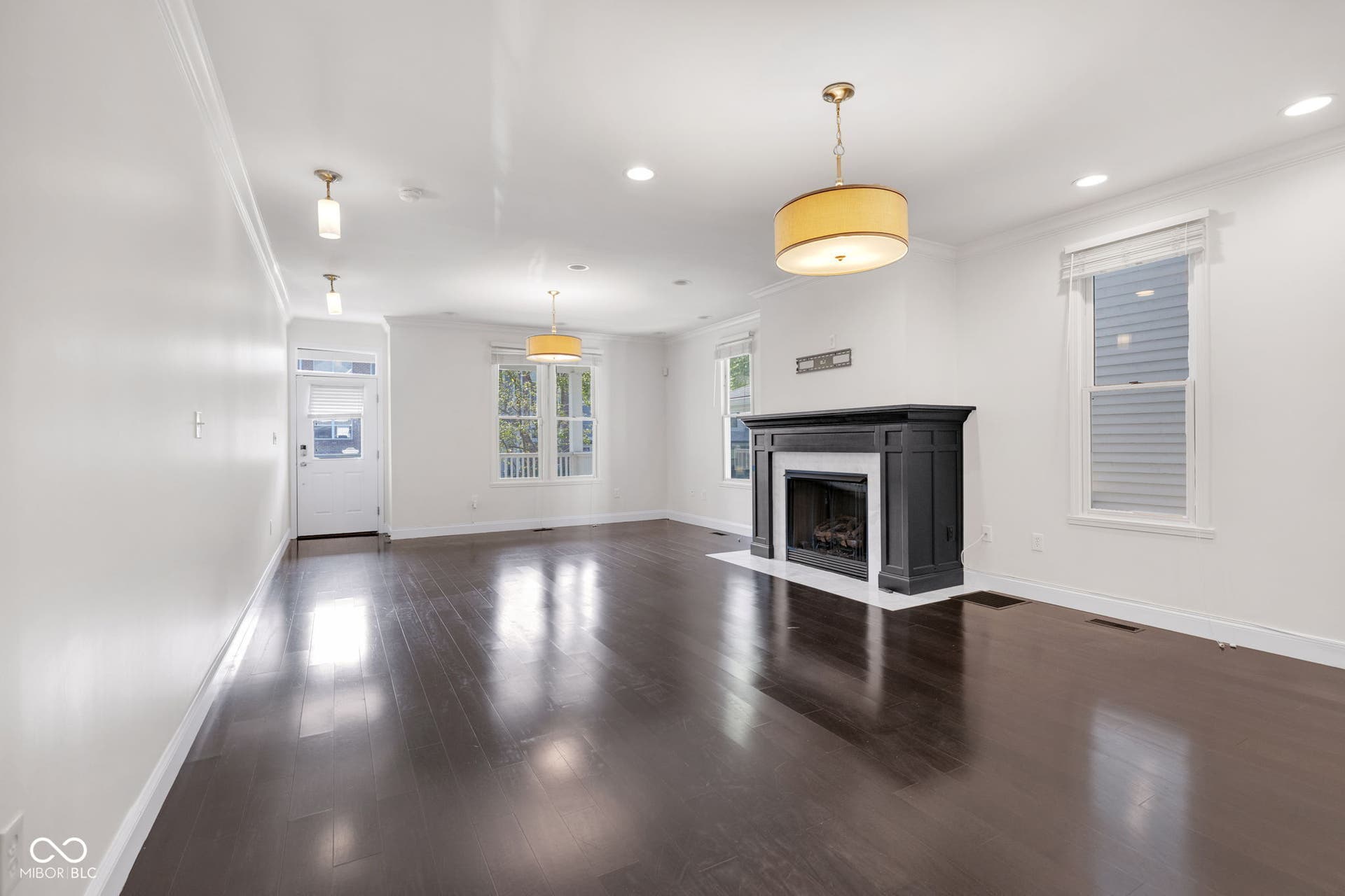 Freshly painted (7/2025) living room featuring crown molding, wood finished floors, a fireplace with flush hearth, and recessed lighting