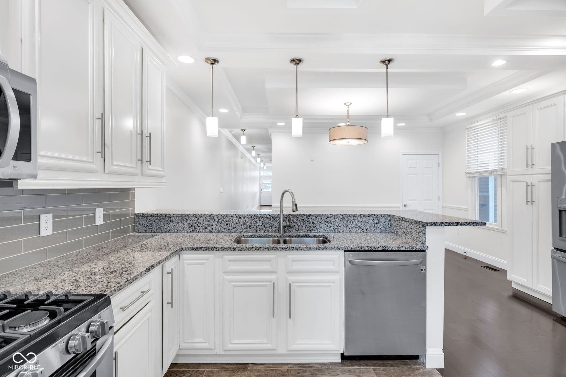 Kitchen & dining area - freshly painted (7/2025) featuring hardwood floors, ample cabinet space, stone countertops and stainless appliances.