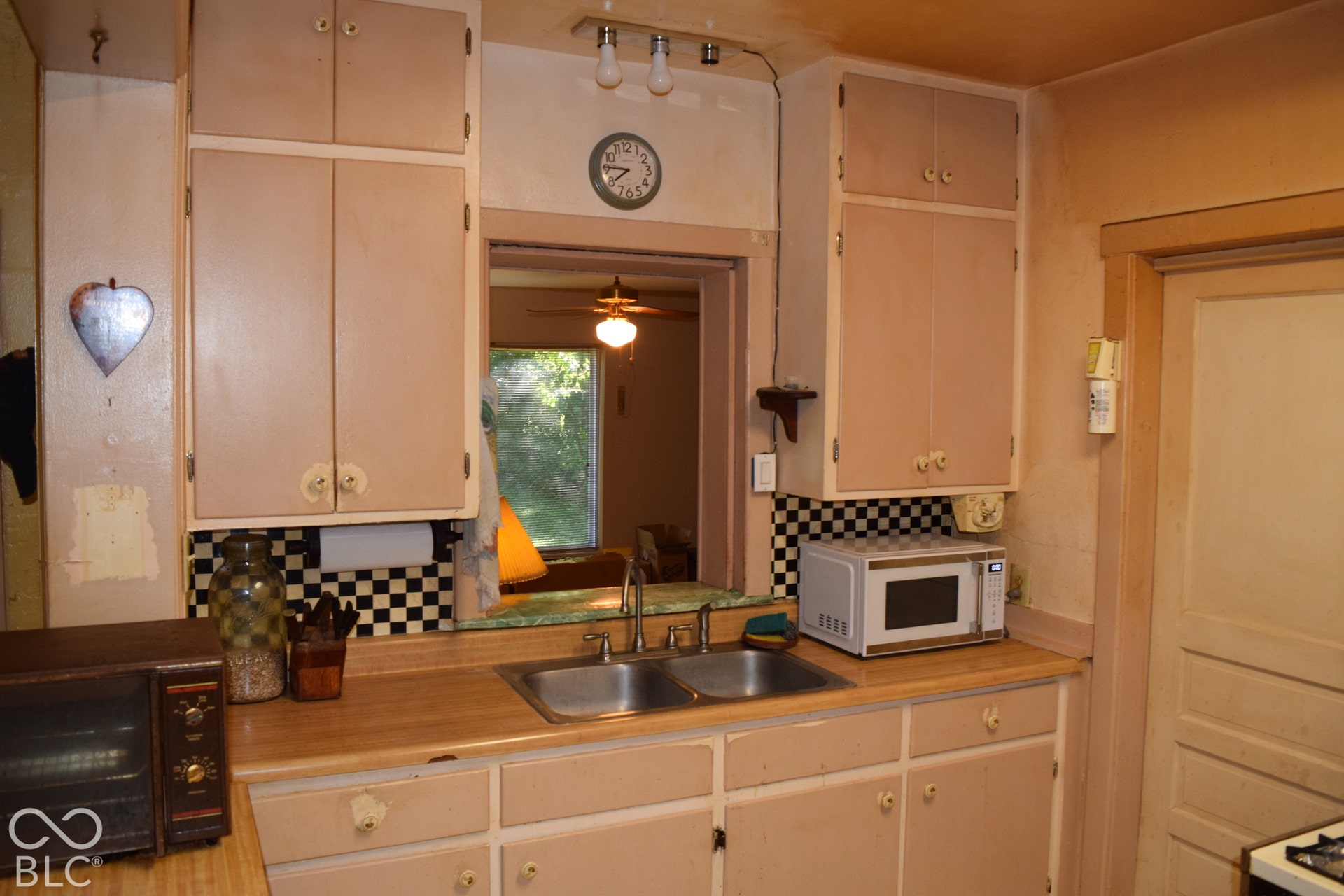 Kitchen featuring wood-finish countertops, checkerboard backsplash, and built-in cabinetry
