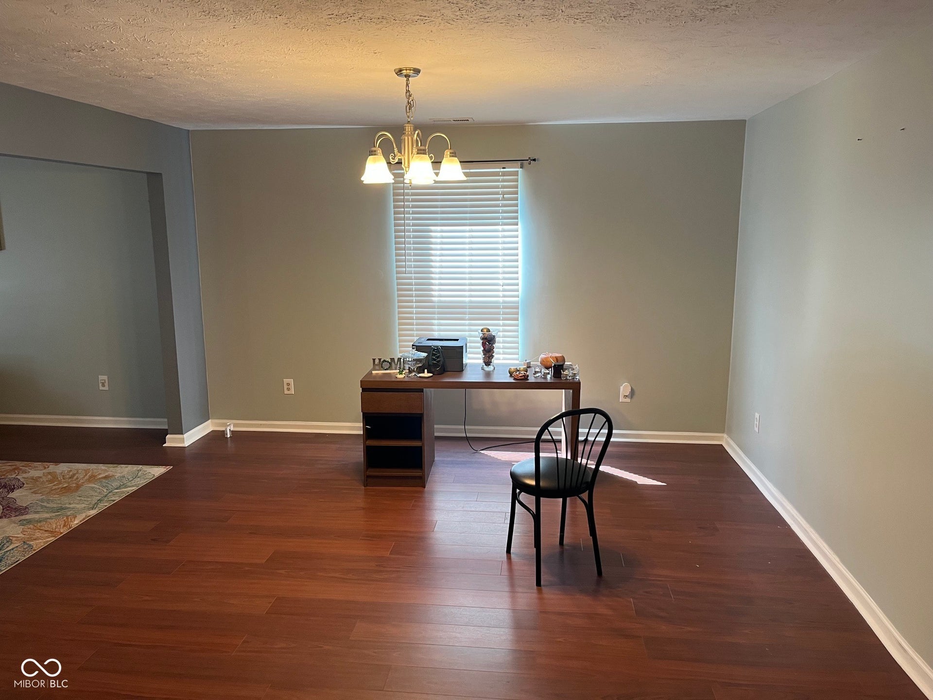 Expansive room featuring wood-finish flooring, neutral wall tones, and a window with horizontal blinds