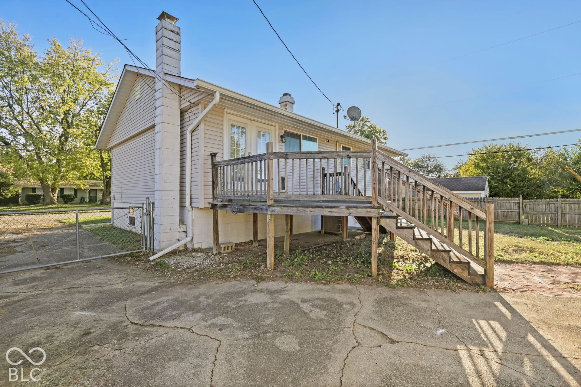 Exterior featuring siding, a prominent chimney, and a wooden deck with stairs