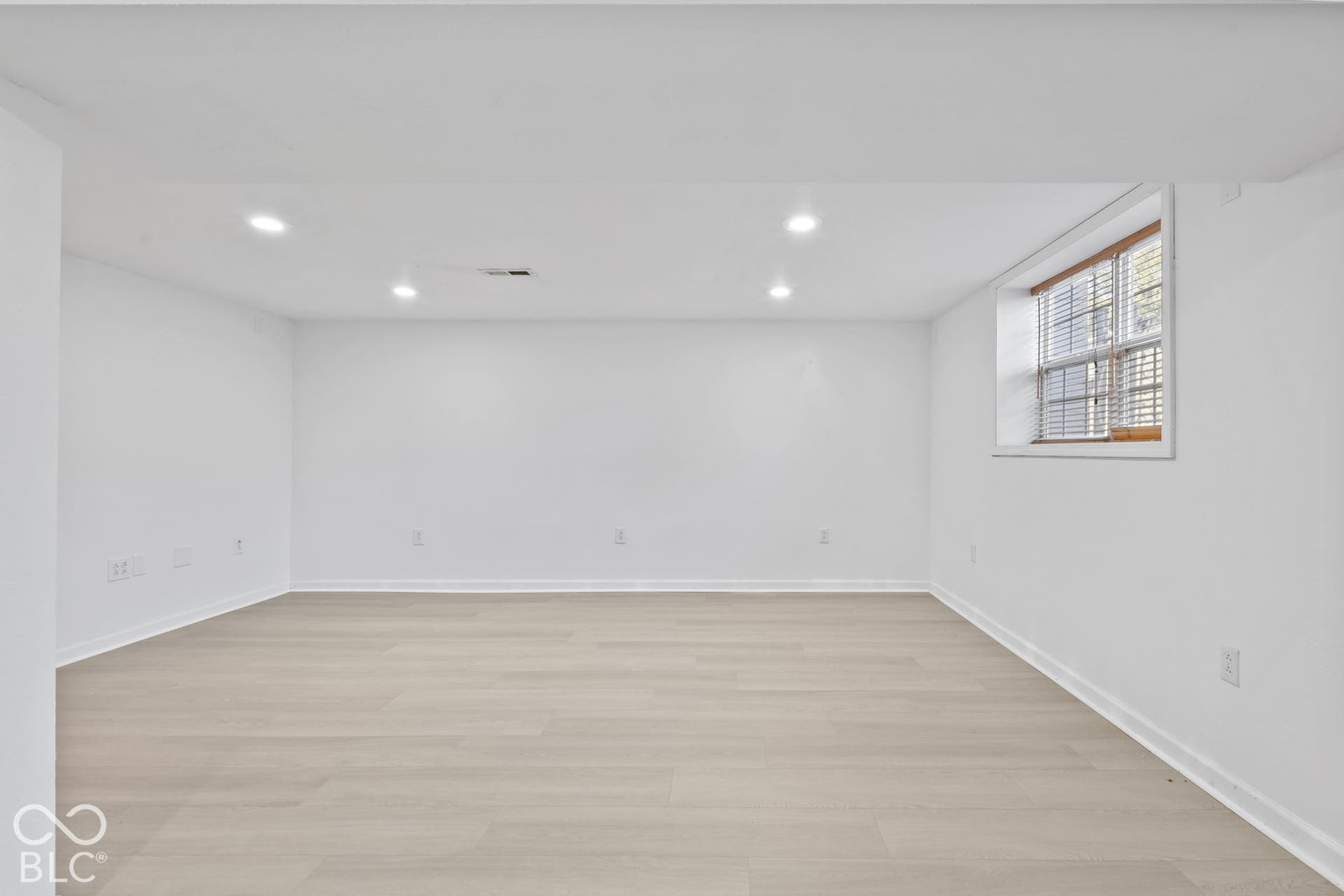 Recessed lighting, wood-finish flooring, white walls, and a window with blinds