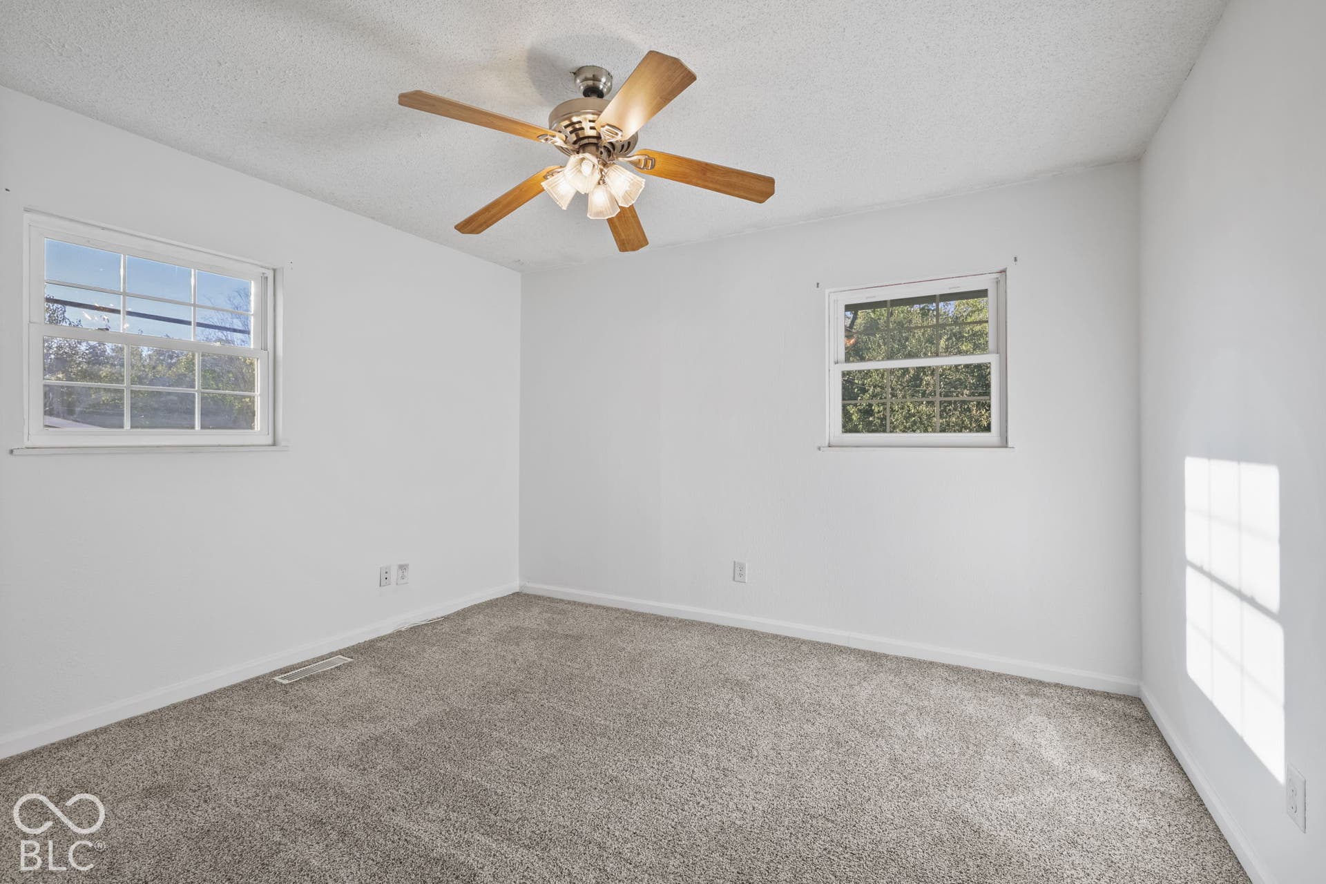Recessed ceiling fan with light fixture, dual windows, and carpet flooring