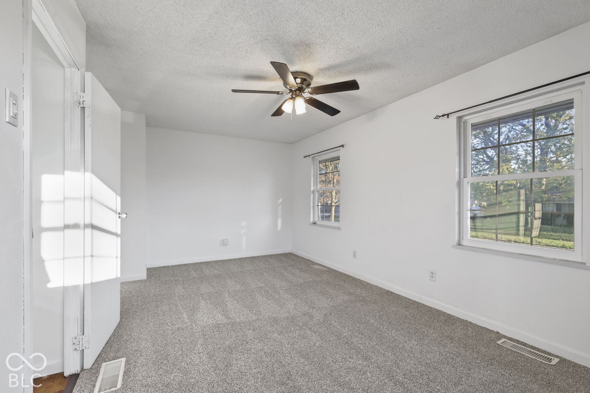 Recessed lighting, ceiling fan, and light-toned carpeting
