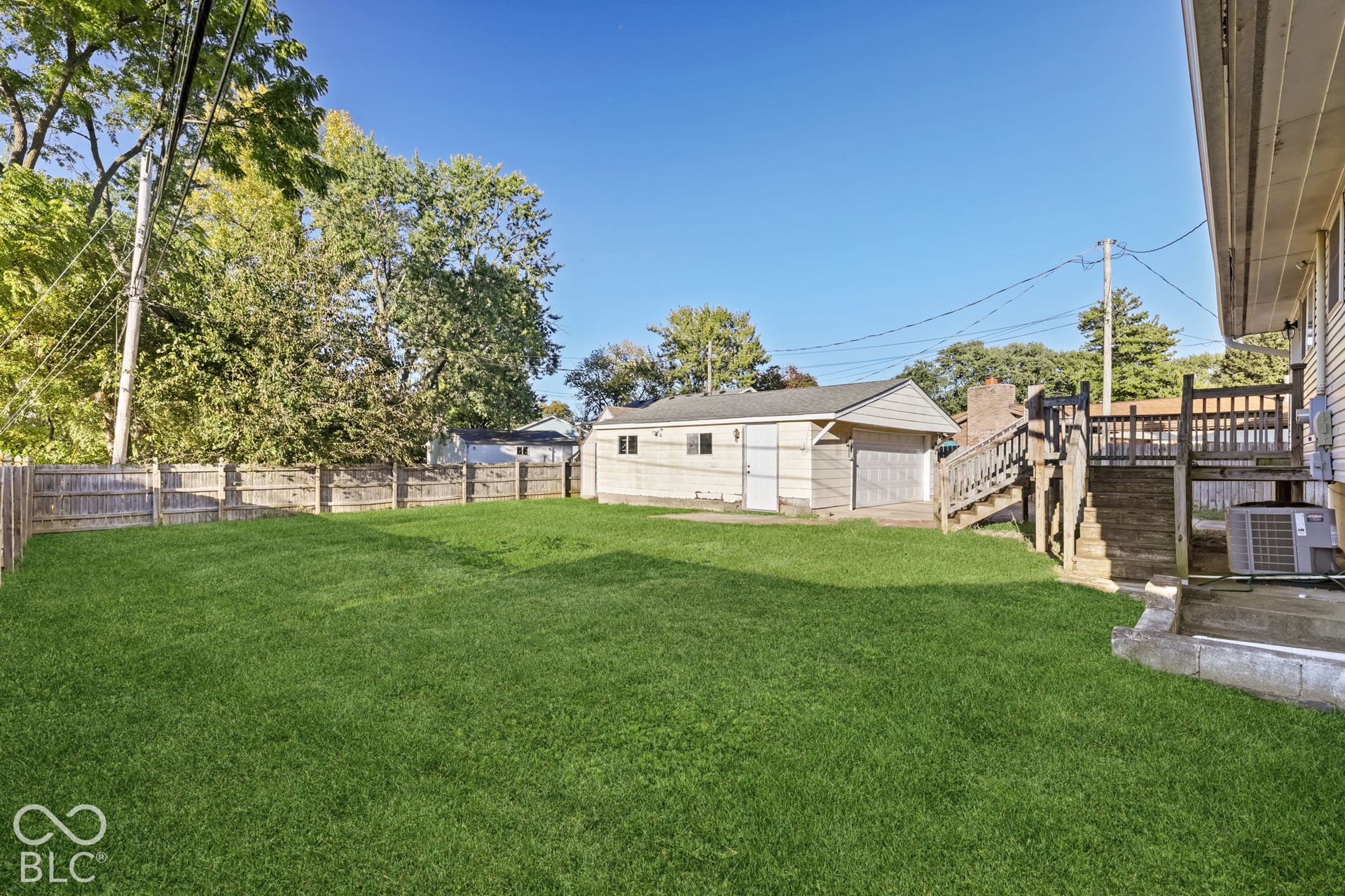 Virtually Altered - Expansive grassy yard with a wood fence perimeter