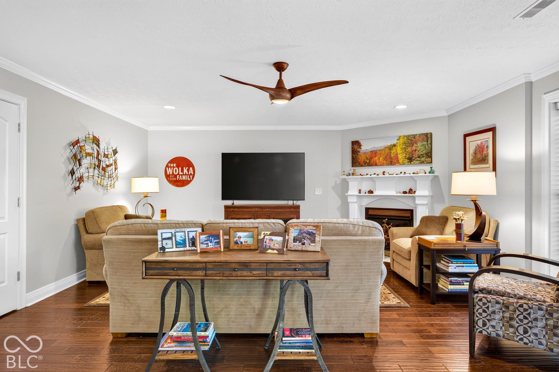 Hardwood flooring, recessed lighting, crown molding, a ceiling fan, and a built-in fireplace