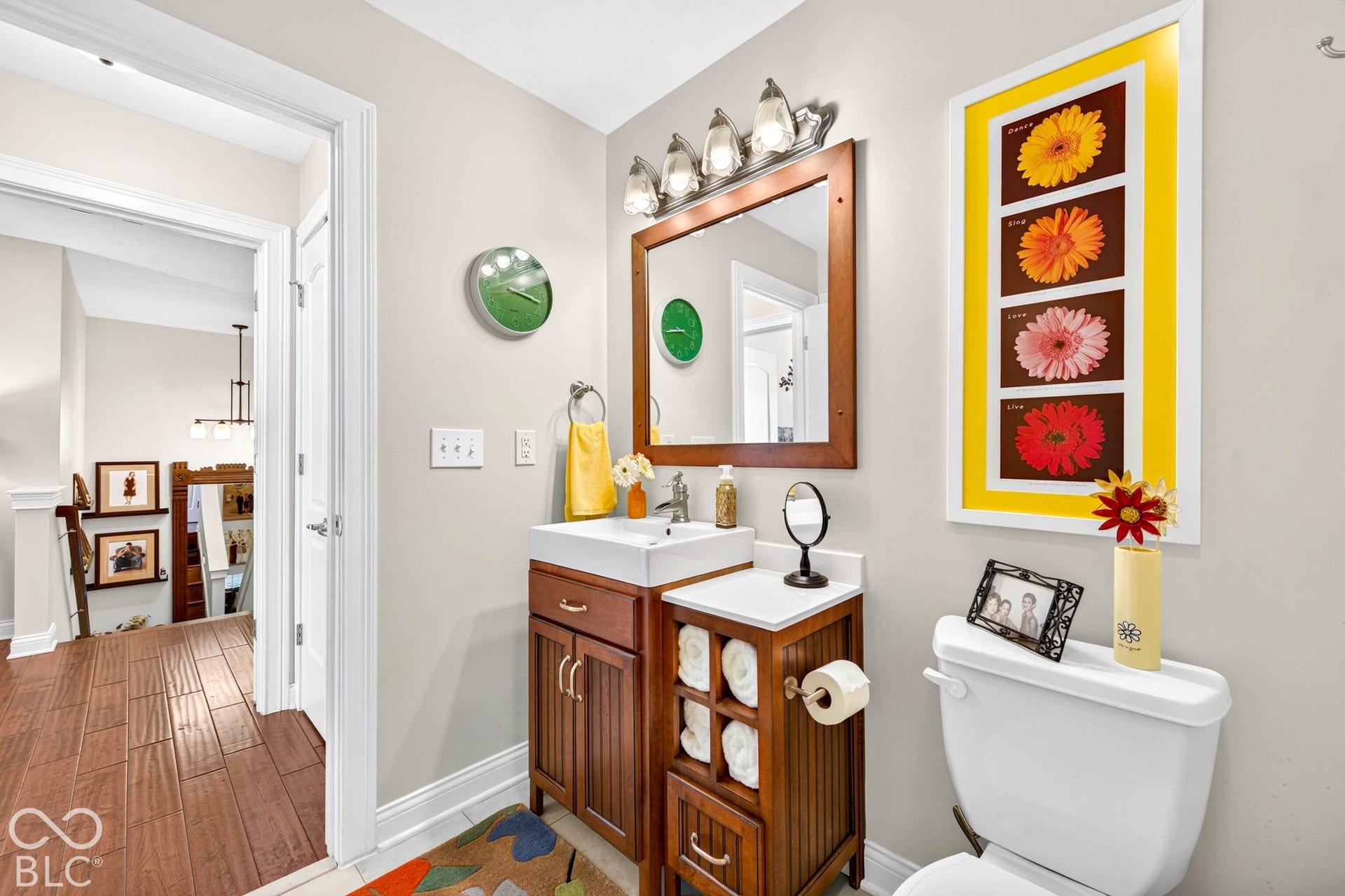 Vanity with a square sink, wood-finish cabinetry, and a wood-framed mirror