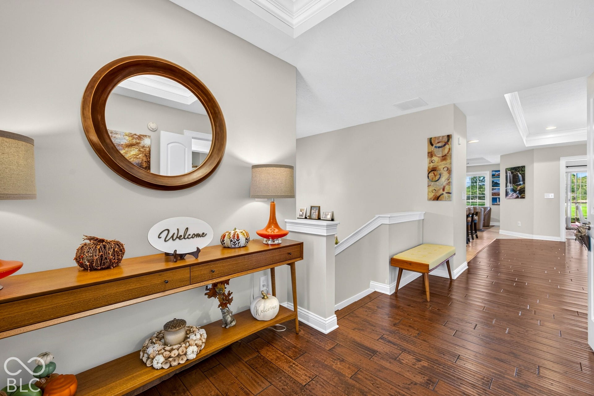 Hardwood-finish flooring extending through the entry, white trim, and light-toned walls