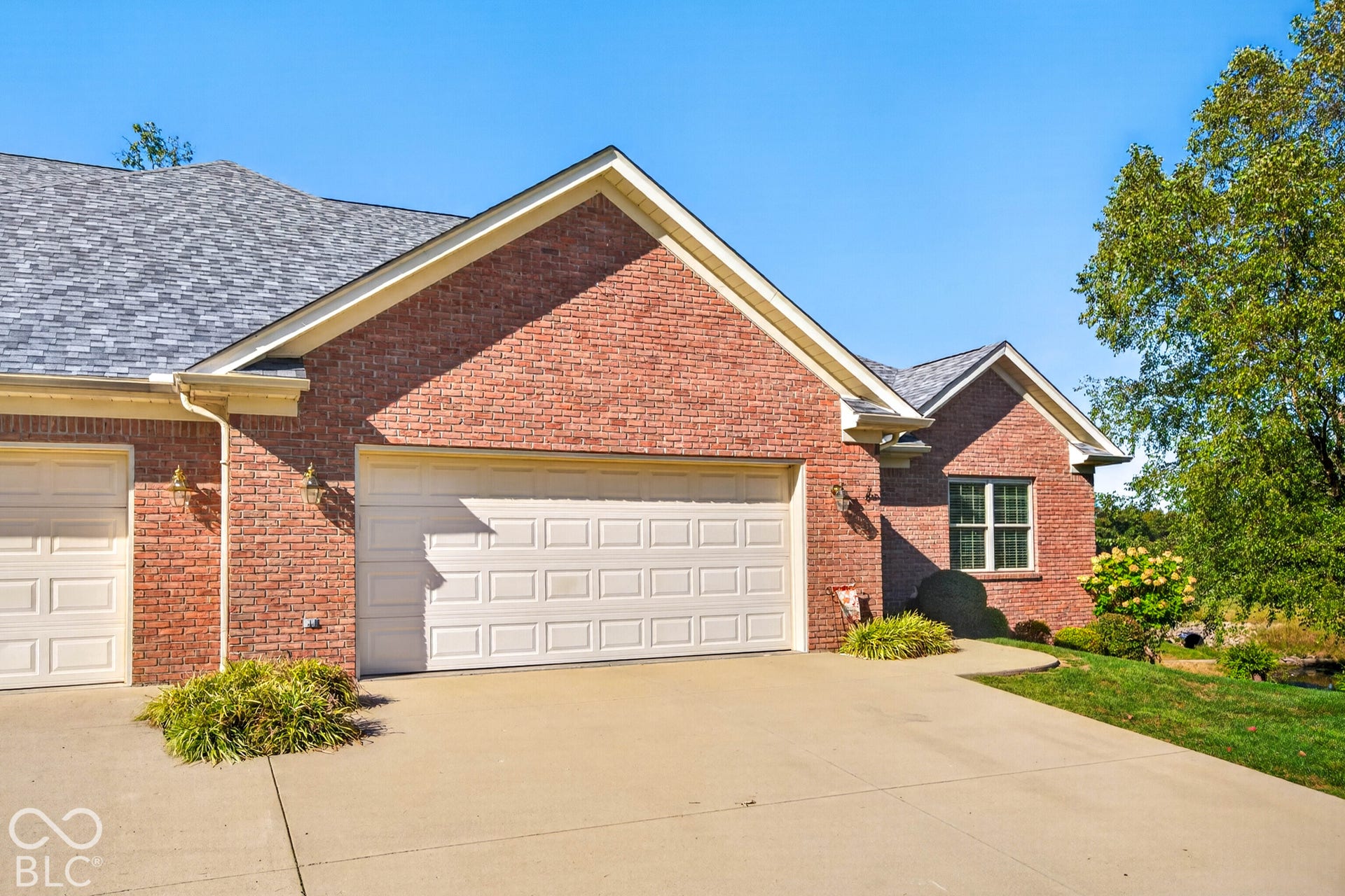 Red brick exterior with light-colored garage doors