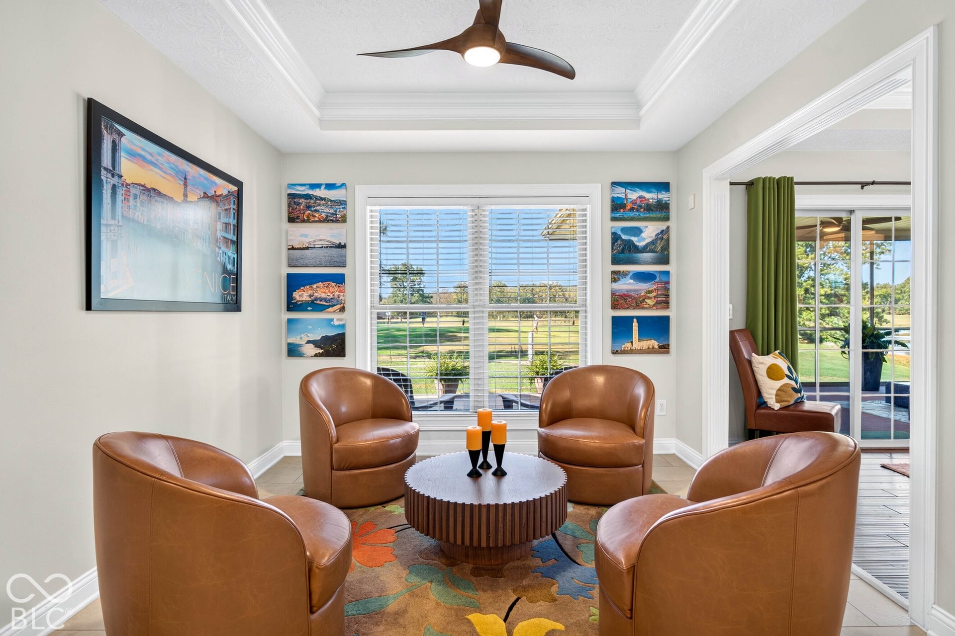 Tray ceiling with a built-in ceiling fan, window with horizontal blinds, and a built-in light fixture