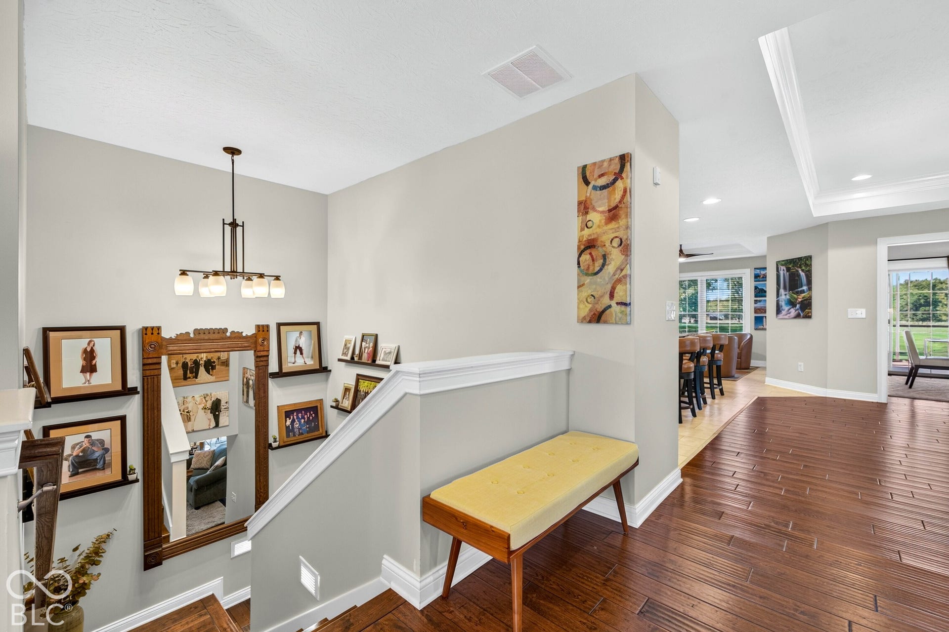 Hardwood flooring, crown molding, modern chandelier, recessed lighting, and a sliding glass door