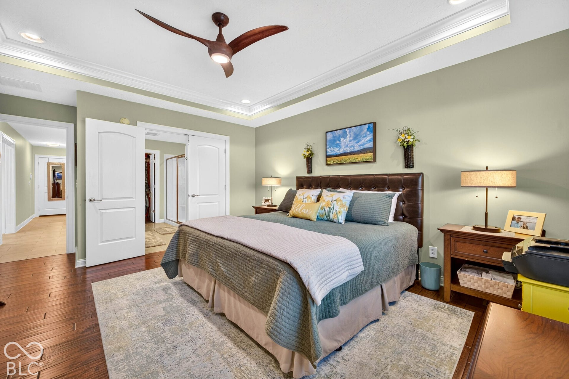 Hardwood flooring, crown molding, a ceiling fan with integrated lighting, recessed lighting, and double-door entry