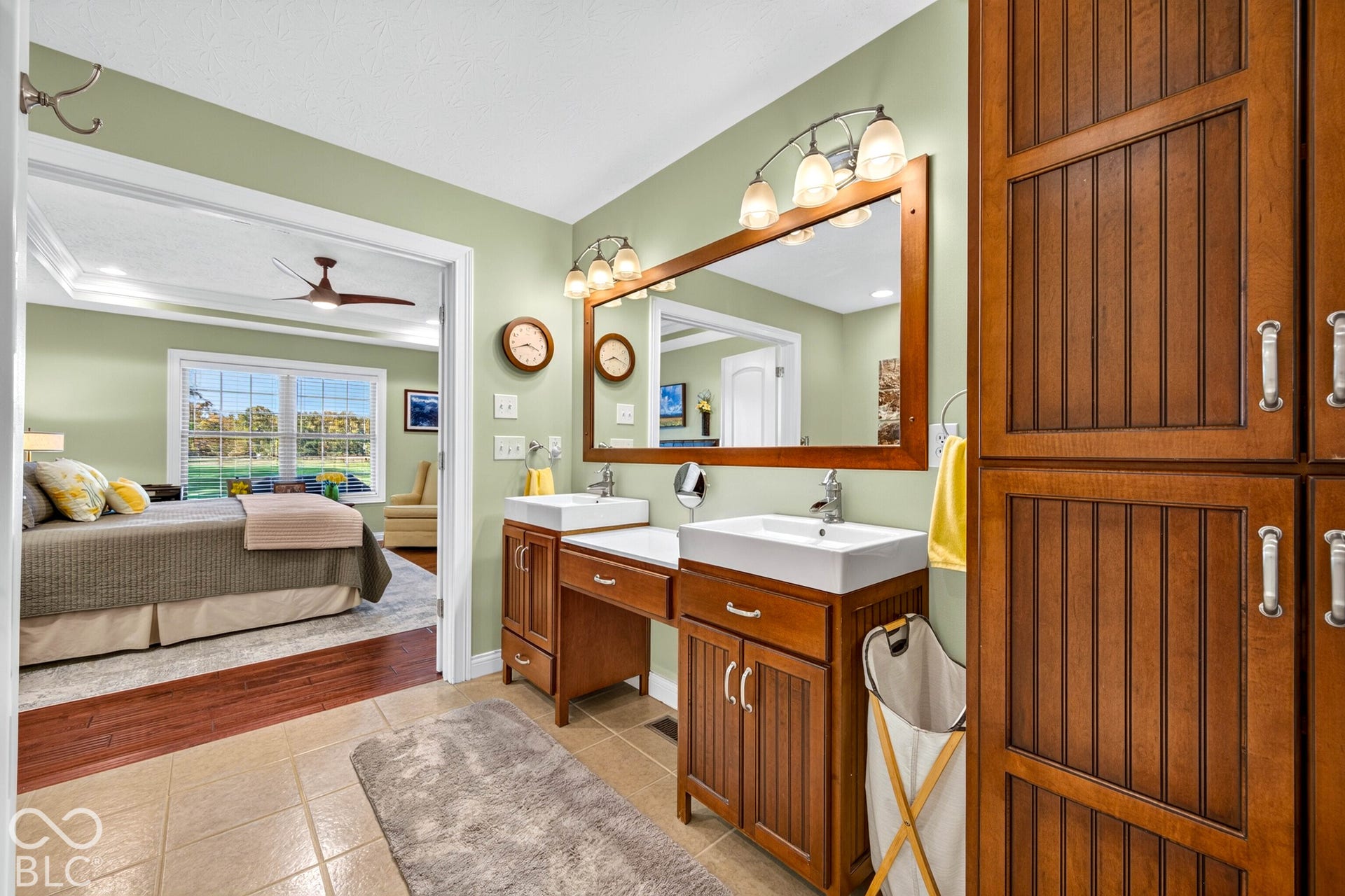 Dual basin vanity with storage, tile flooring, and integrated storage cabinetry