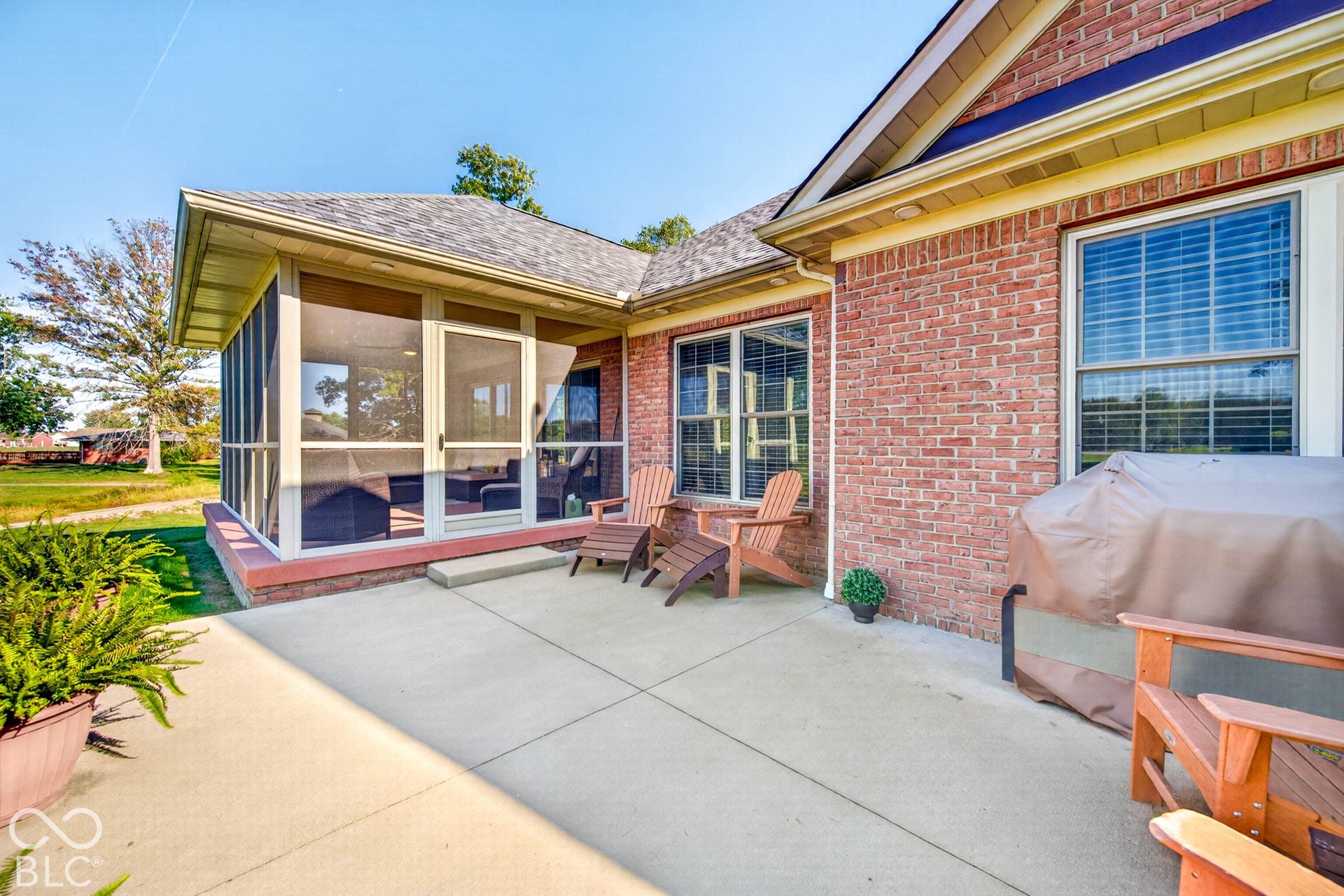 Patio with concrete surfacing, red brick exterior, and a screened-in porch with multiple windows