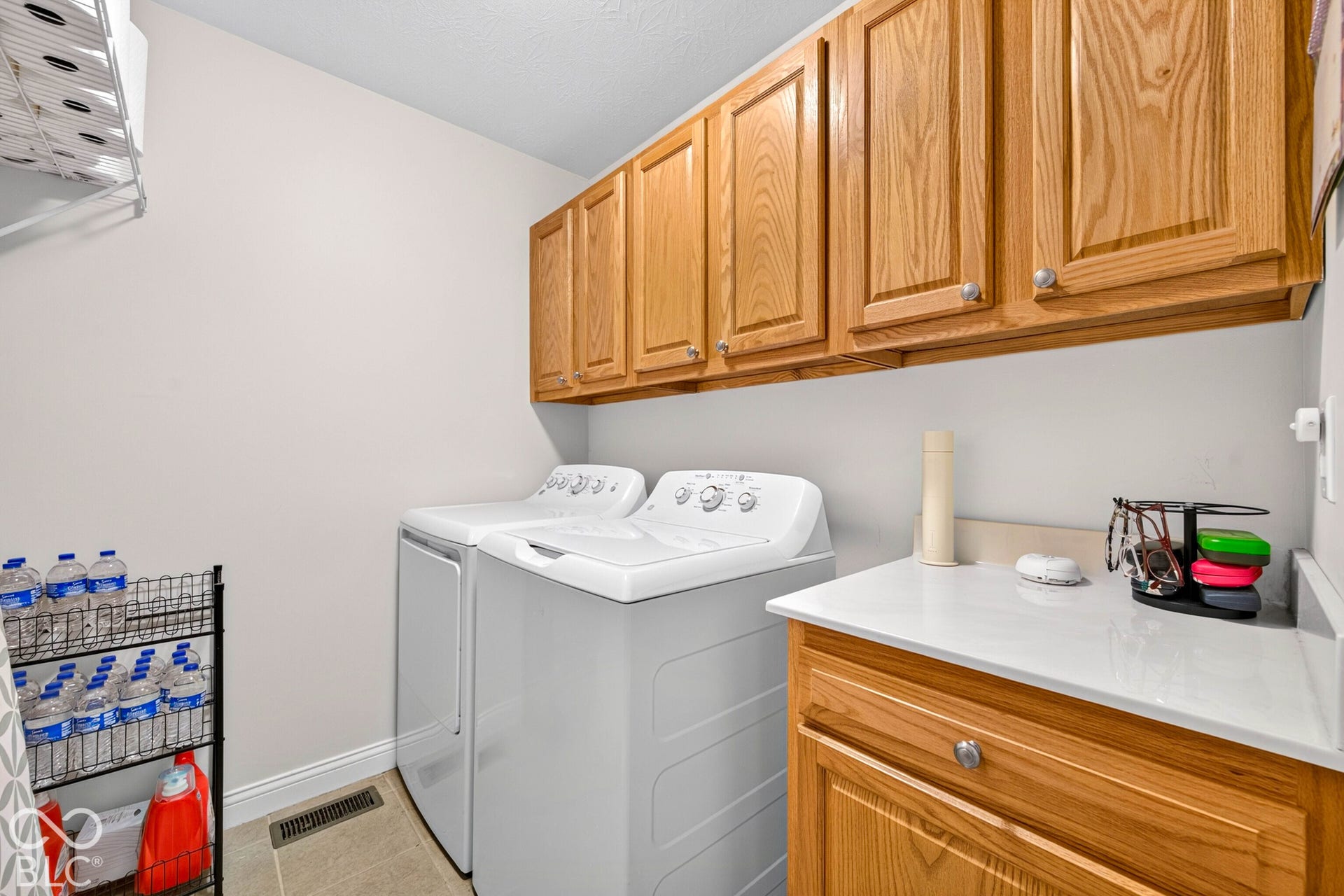Utility space featuring wood cabinetry, white countertops, and tile flooring