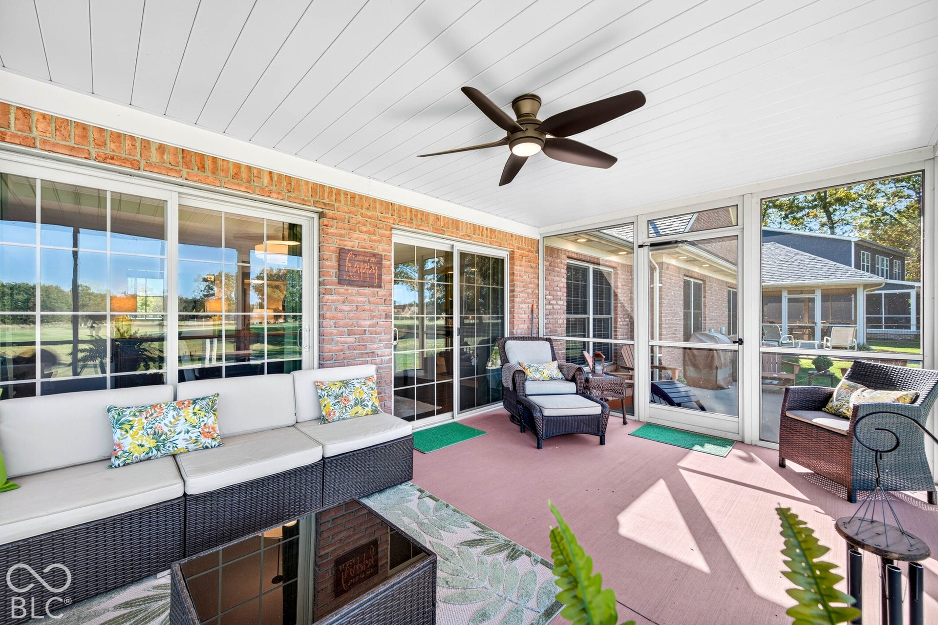 Screened porch with brick exterior wall, a ceiling fan, and multiple sliding glass doors
