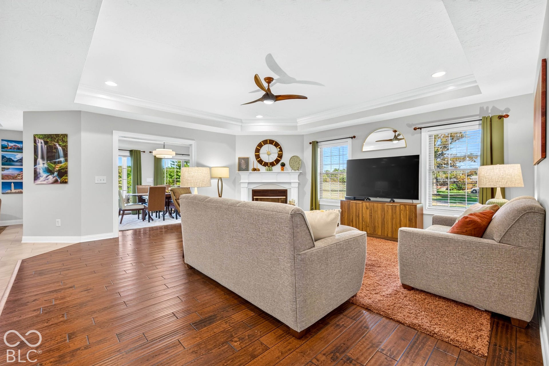 Wood-finish flooring with a tray ceiling and recessed lighting