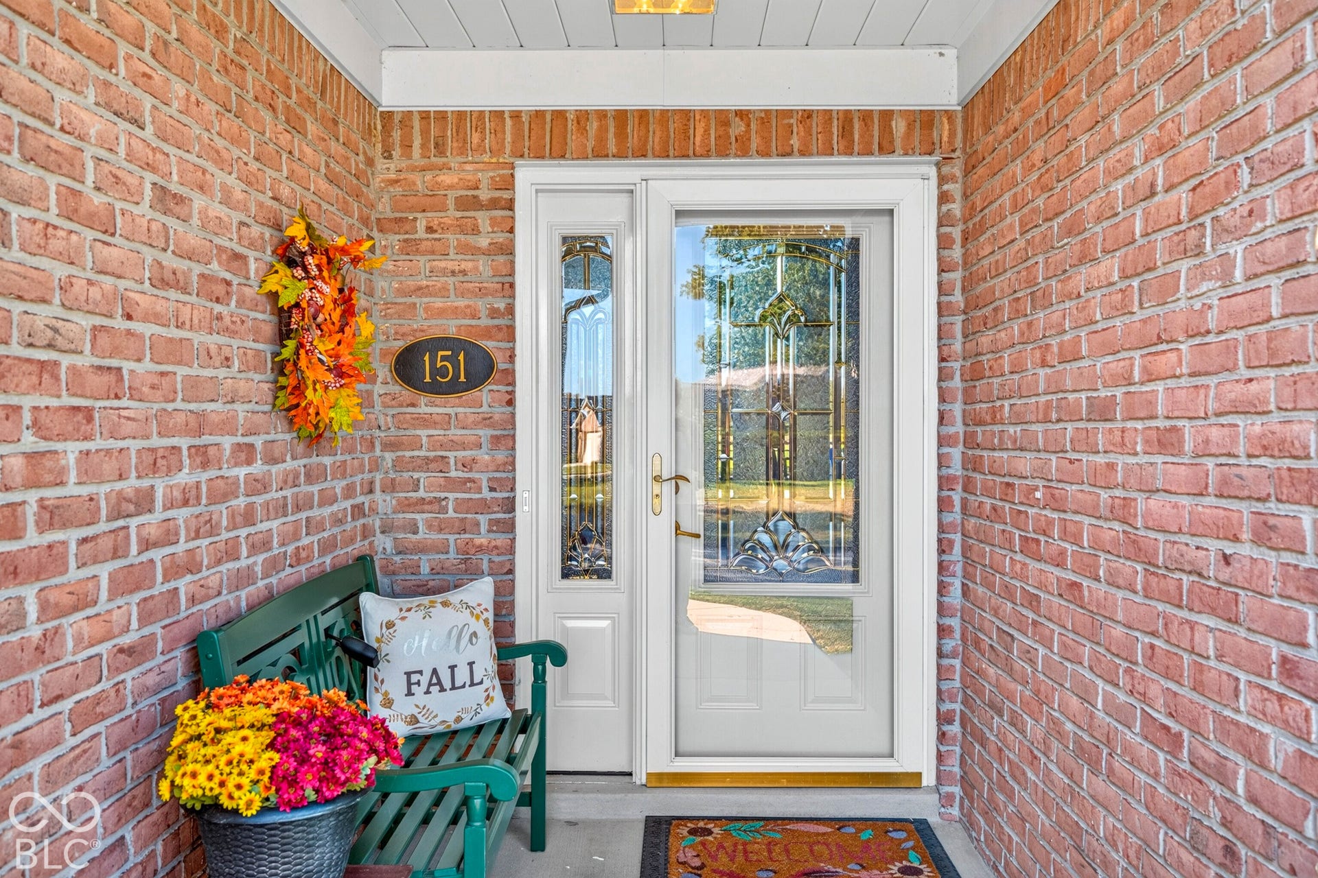 Brick exterior with a white entry door featuring decorative glass