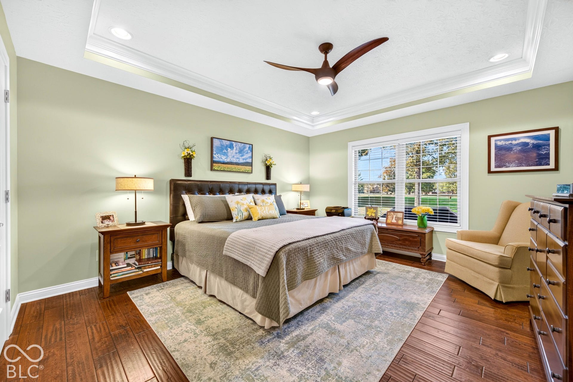 Tray ceiling with recessed lighting, wood-finish flooring, and a ceiling fan