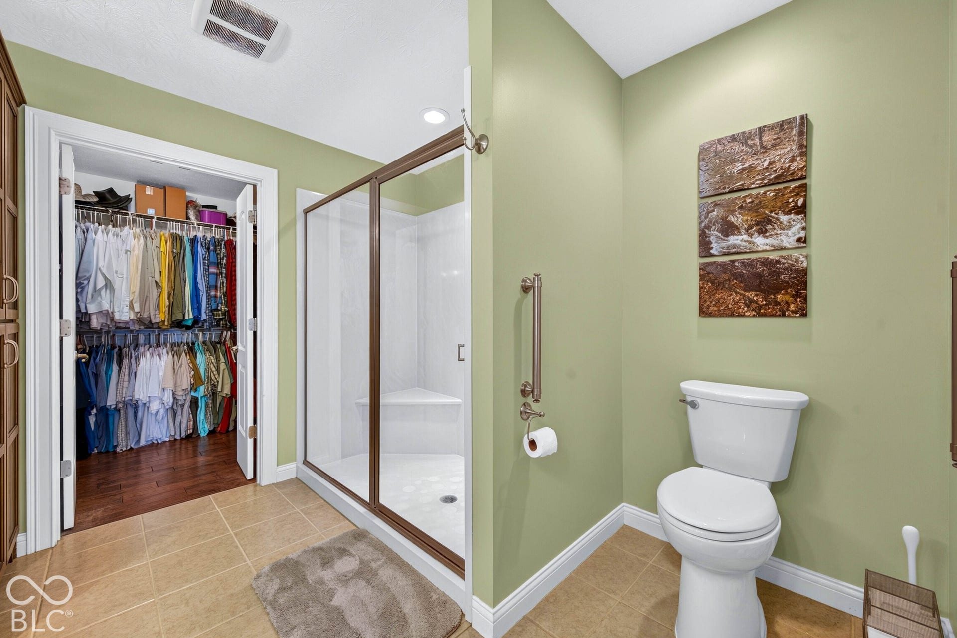 Walk-in shower with a built-in bench, glass enclosure, and bronze-finish frame