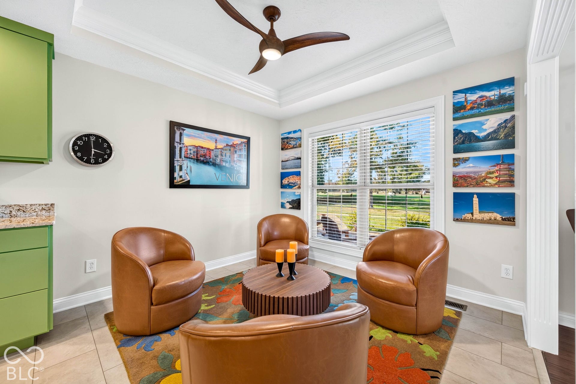 Tray ceiling with a ceiling fan, white wall trim, and tile flooring