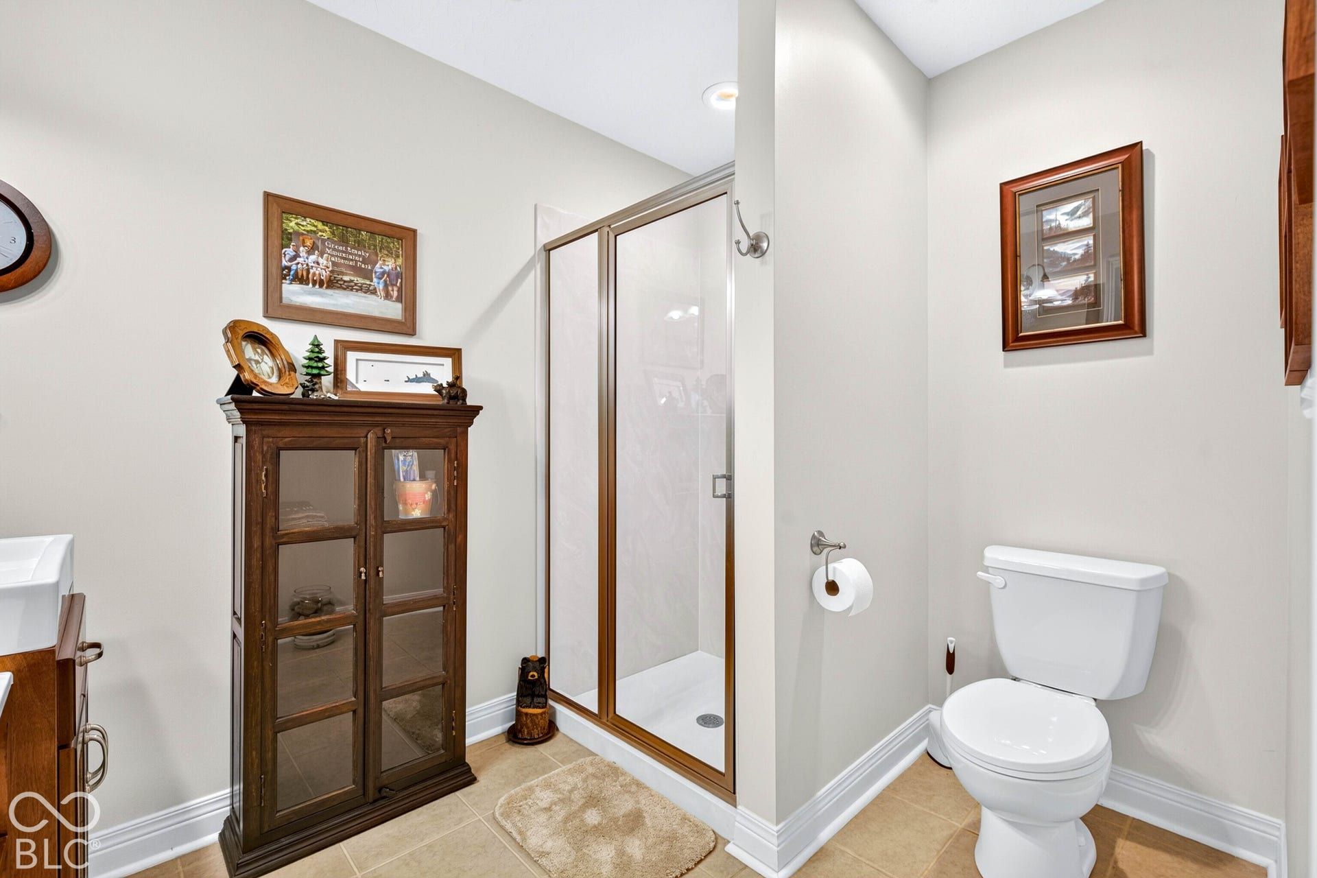 Tiled flooring, white baseboards, and a glass-enclosed shower