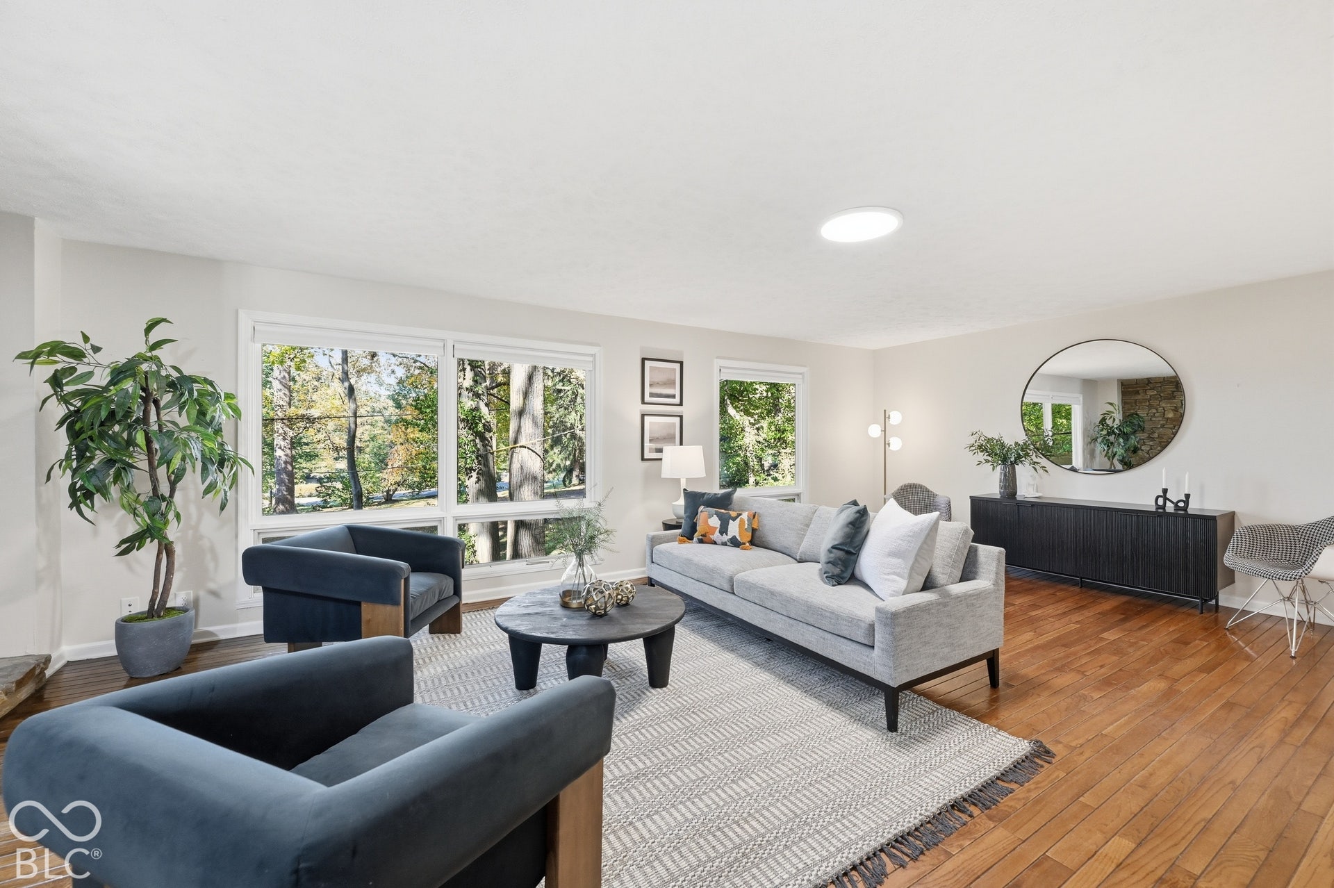 A wall of glass into the treetops. Clyde E. Woods oriented these windows north so the living room glows with indirect light from morning to evening, and every fall the leaves change right outside.