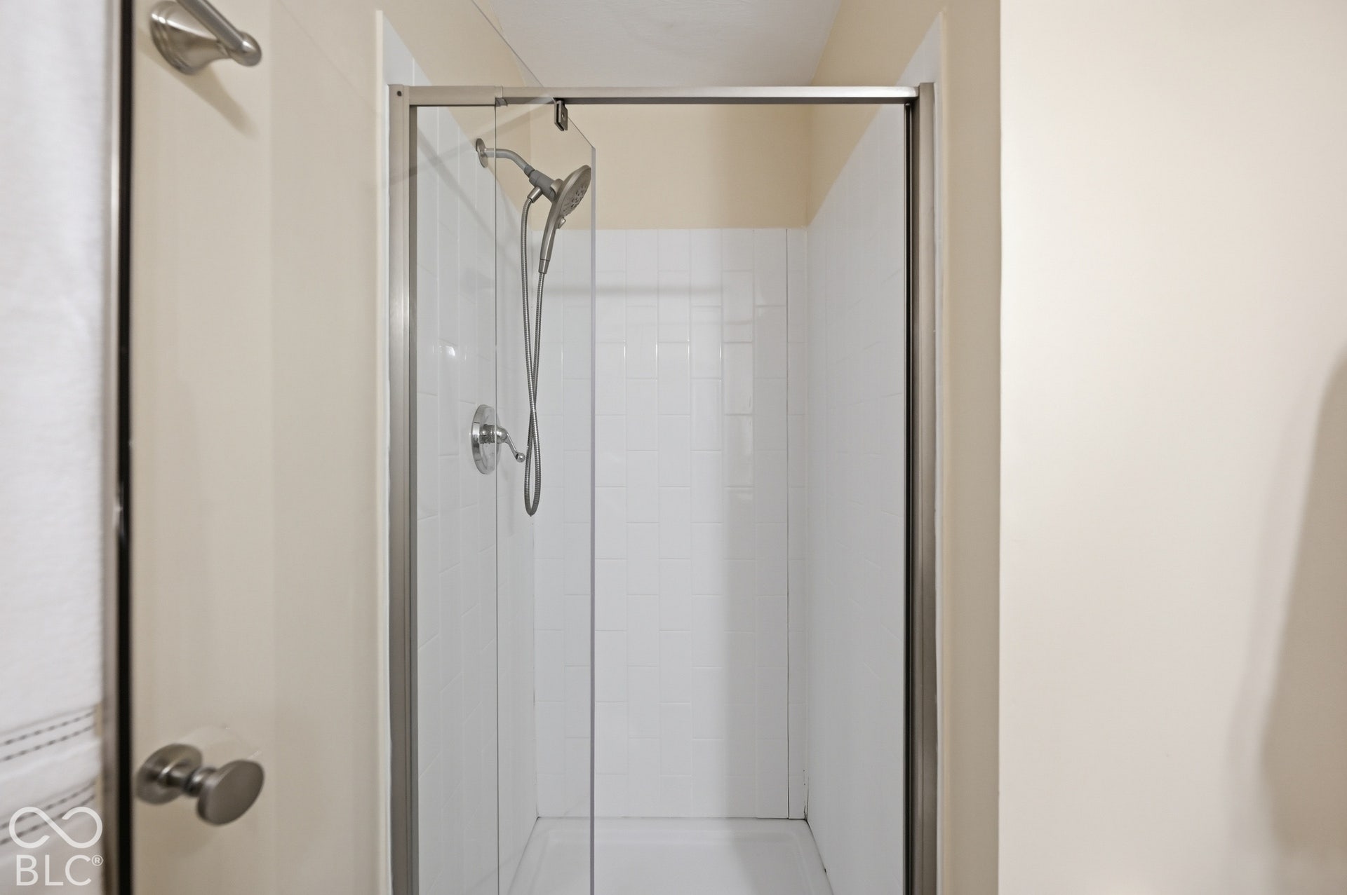 Primary bath walk-in shower with glass enclosure and handheld shower head, updated for today.