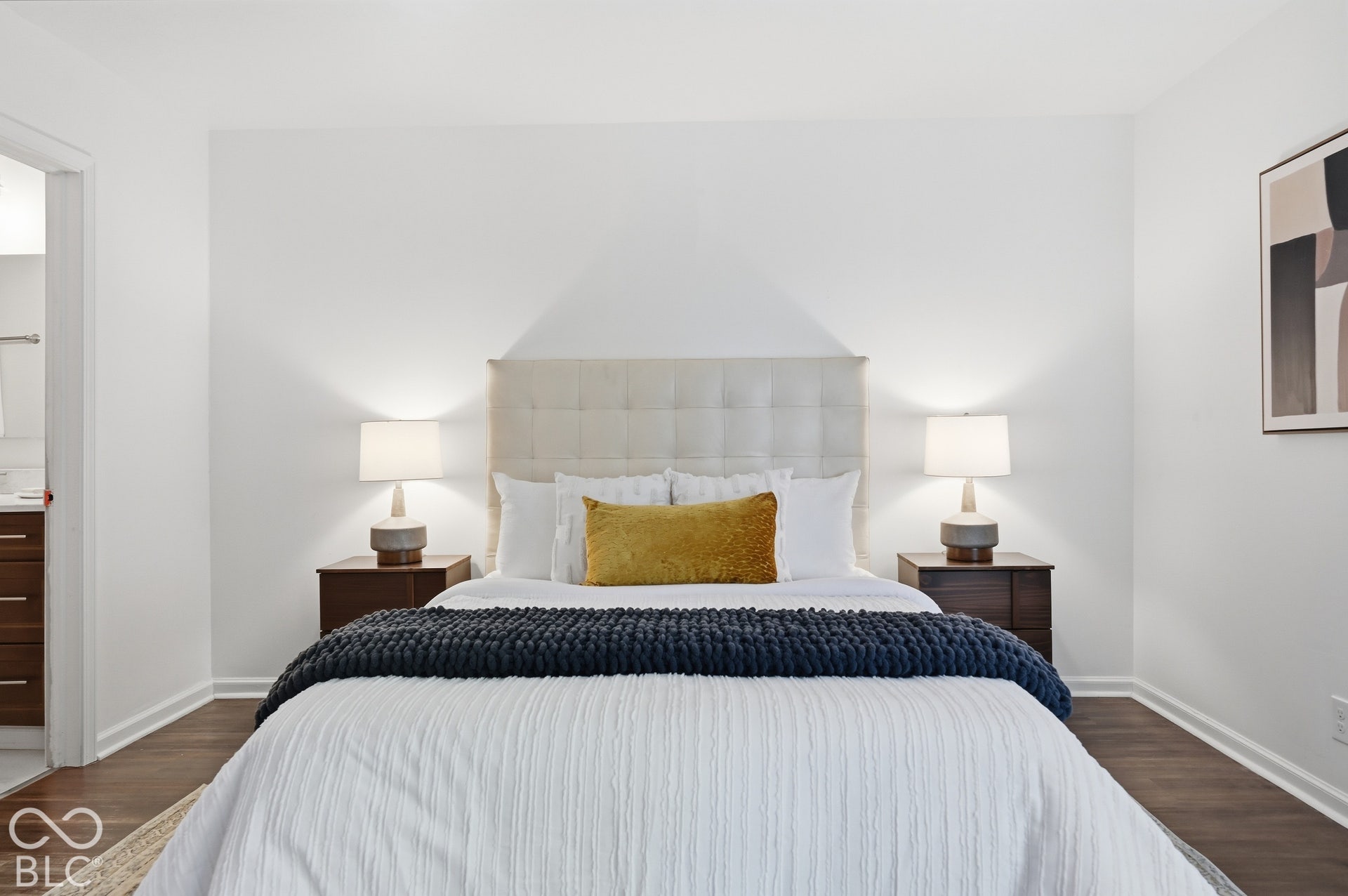 Primary bedroom with room for a king bed and nightstands, dark-tone floors and soft natural light.