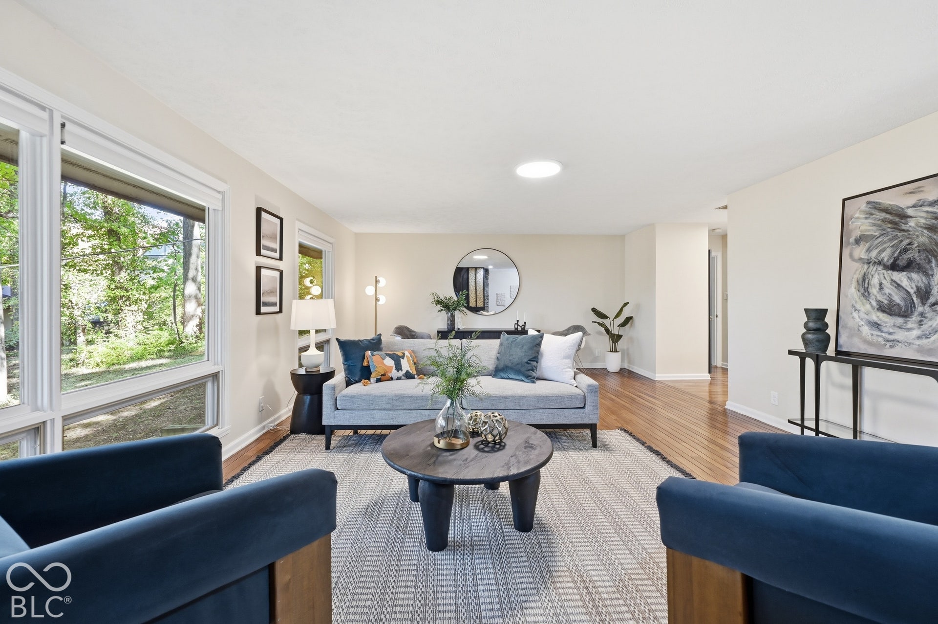 Room to gather. The living room's scale, hardwood floors and windows on two sides make it easy to host a crowd, or settle in with a jazz record and watch the woods.