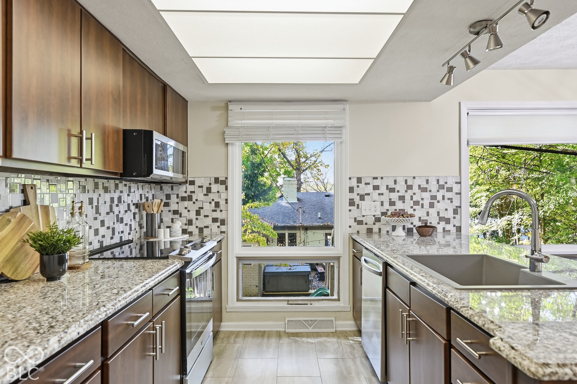 Kitchen windows look straight into the trees. Granite counters, an oversized sink, stainless appliances and generous cabinetry make this a kitchen for real cooking.