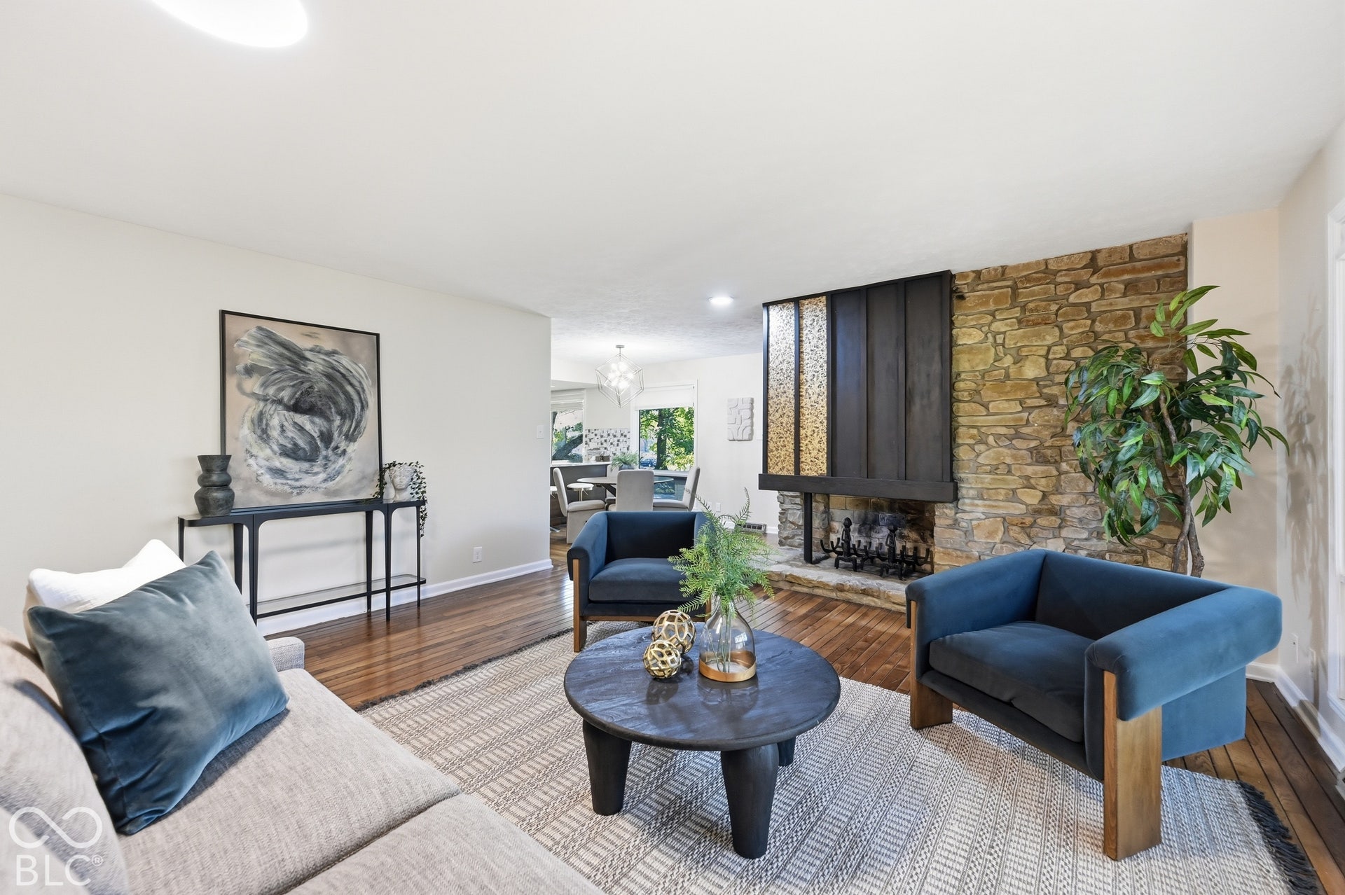 Living room with the statement stone fireplace and its textured mosaic panel, original architectural details from 1967 that give the Woods House its character.