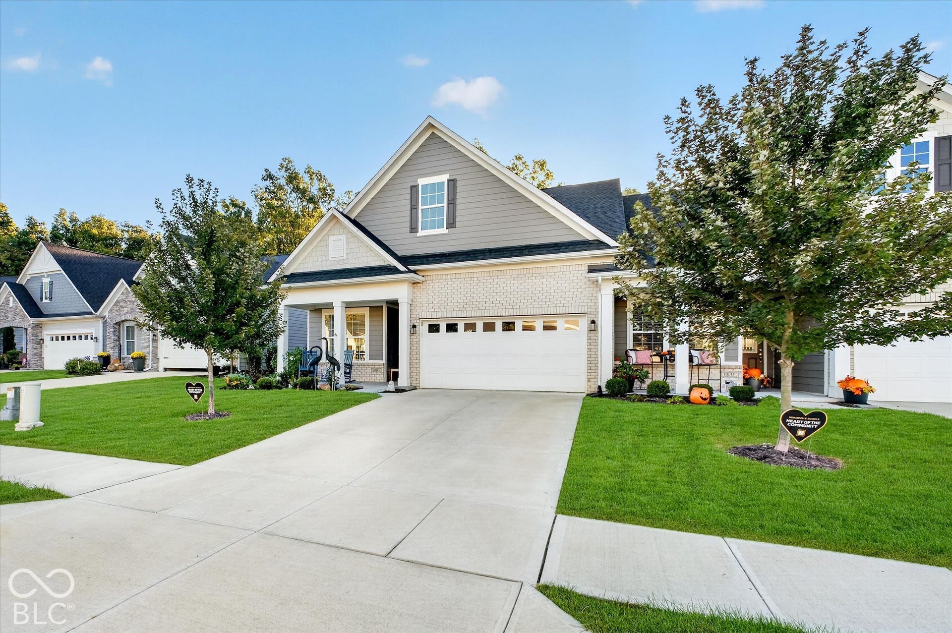 Two-car garage, covered entry, and brick facade with horizontal siding accents