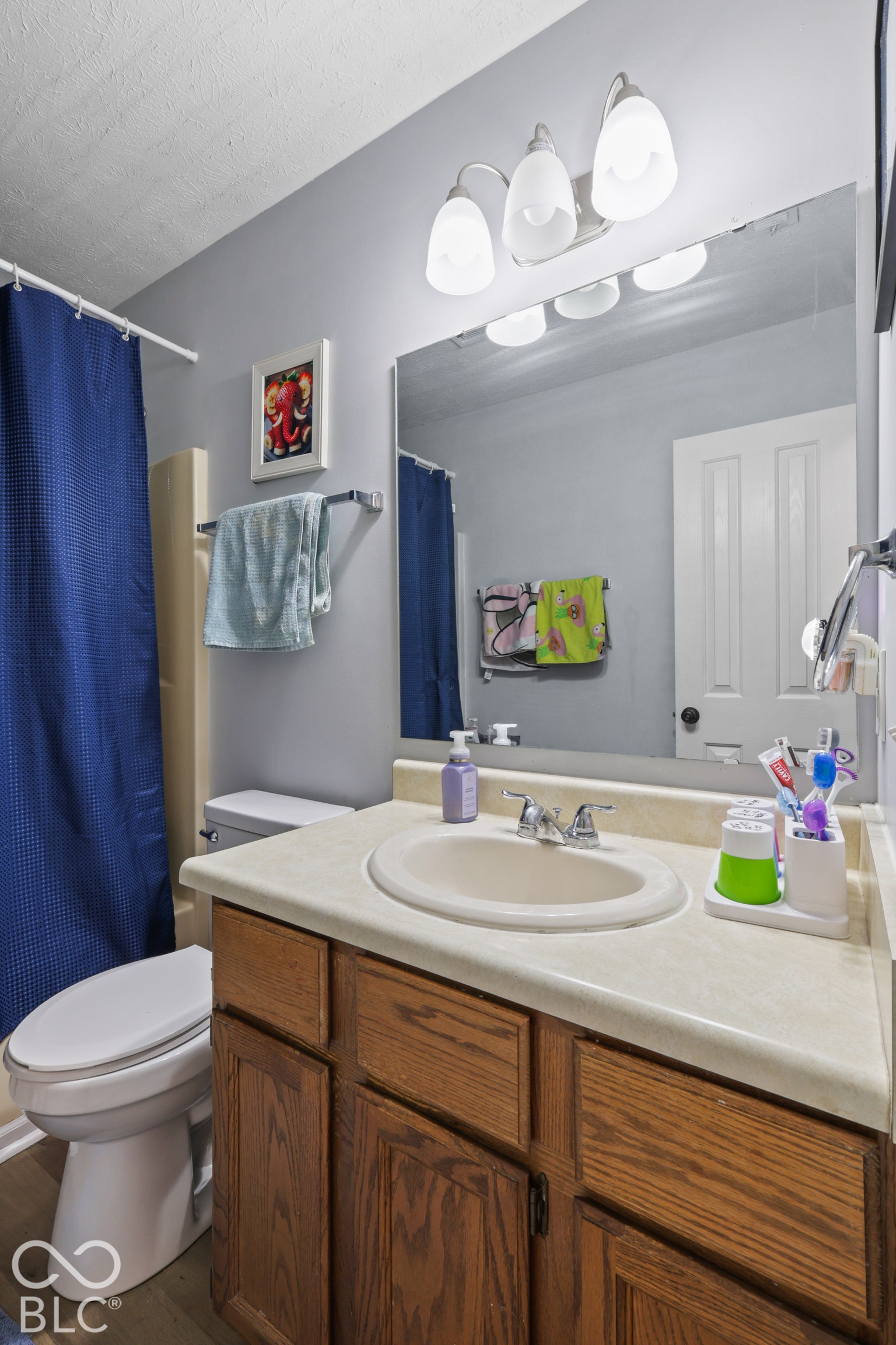 Bathroom featuring a vanity with a laminate countertop, an integrated sink, and wood-finish cabinetry