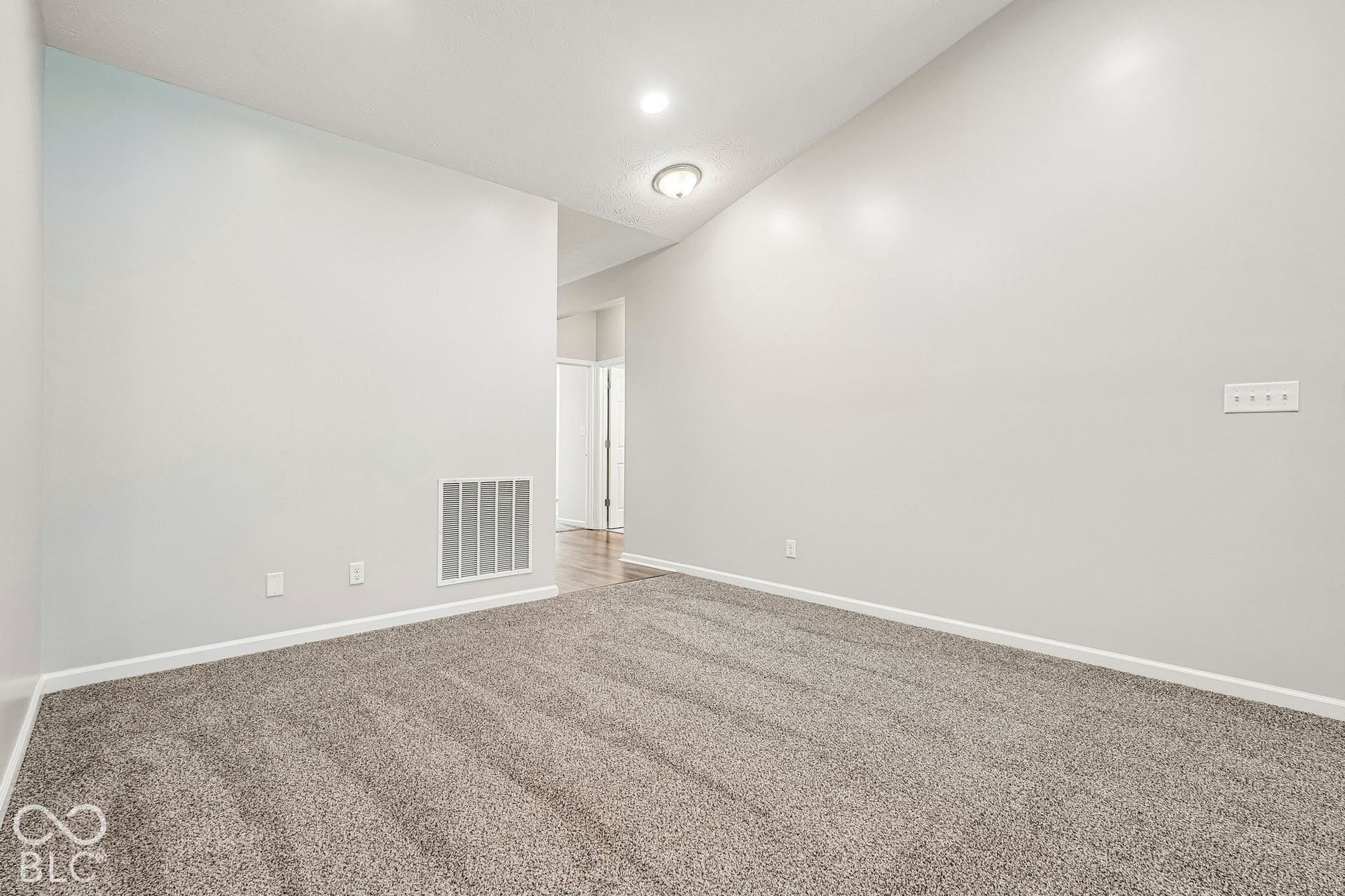 Plush carpet flooring, recessed ceiling lighting, sloped ceiling, and wood-finish flooring in the background