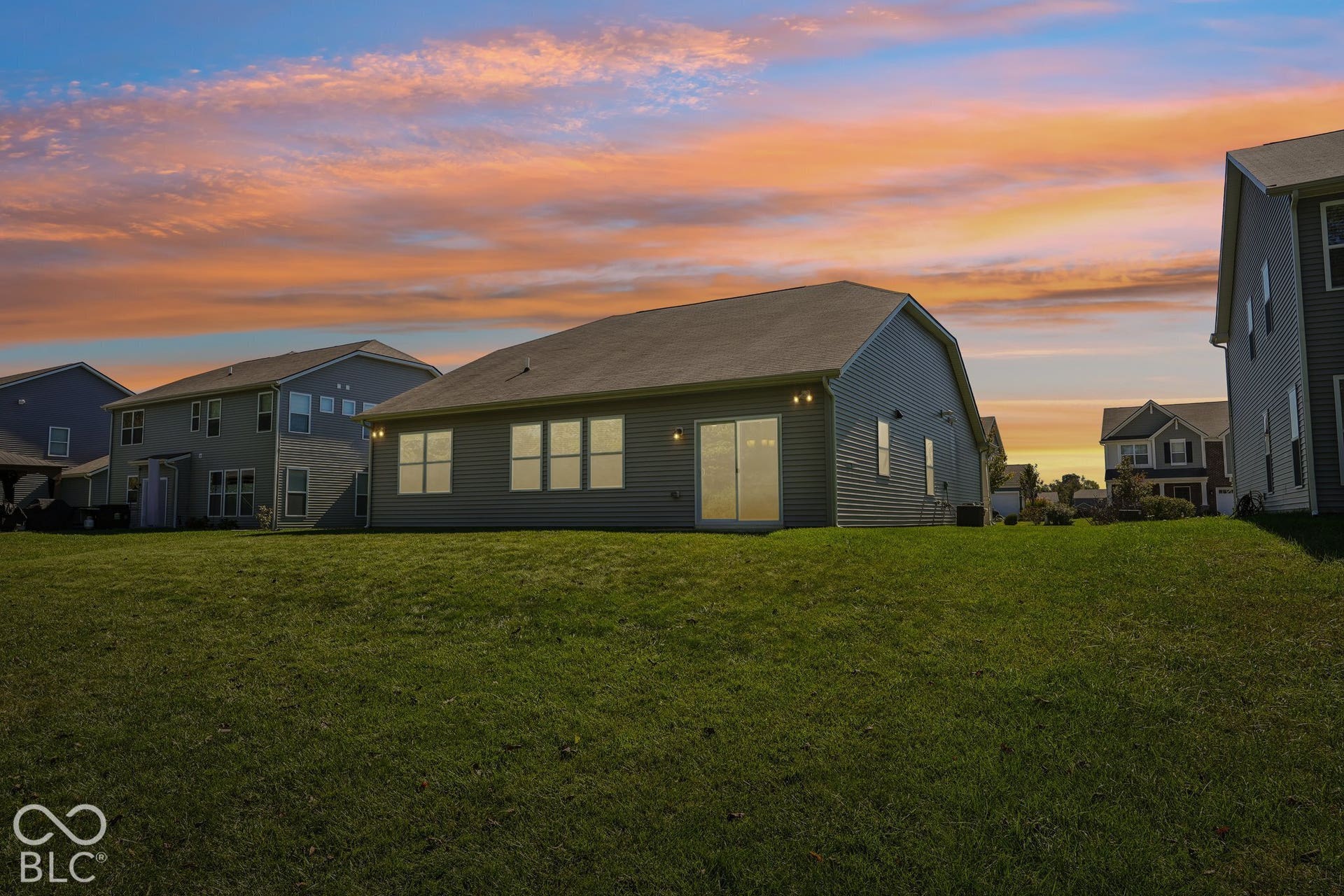 Virtually Altered - Rear exterior with siding, multiple windows, and a sliding glass door
