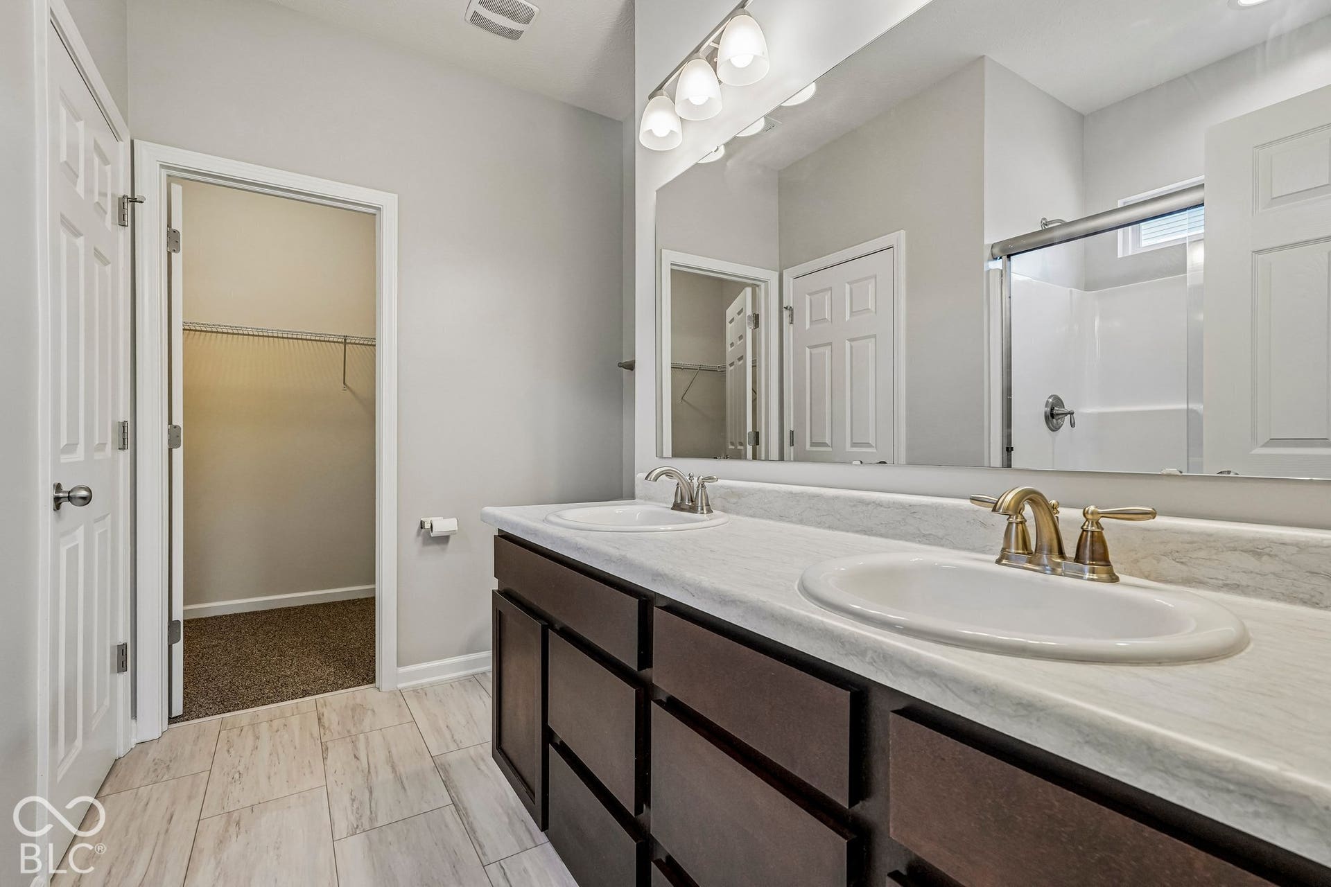 Dual vanity with undermount sinks and brass-finish fixtures