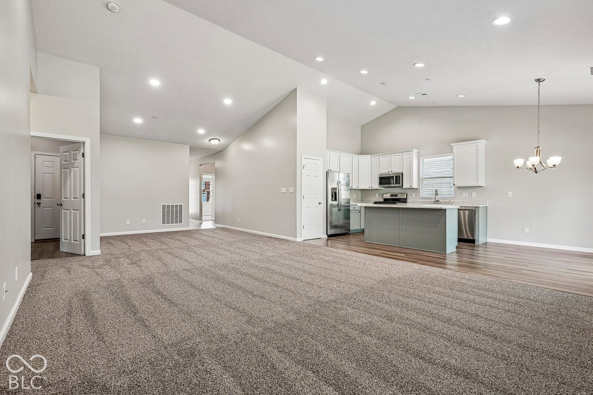 Vaulted ceilings, recessed lighting, and wood-finish flooring