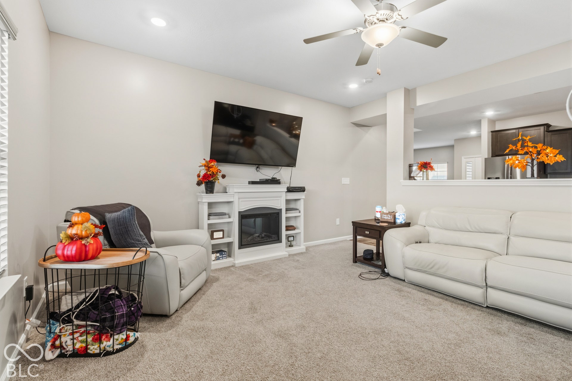 Built-in white entertainment center with an electric fireplace, recessed lighting, and a ceiling fan with integrated lighting