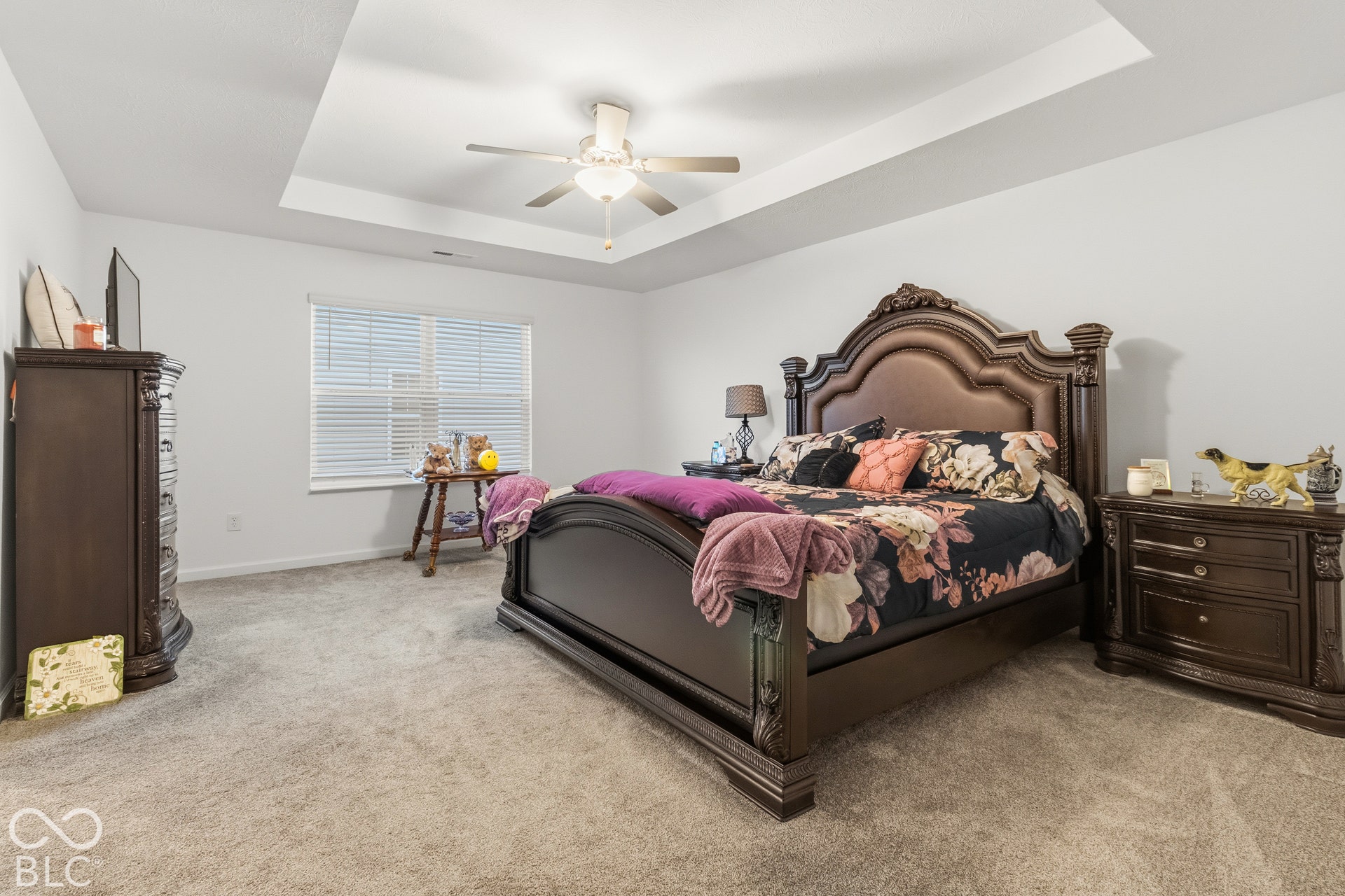Tray ceiling with a ceiling fan, light gray wall paint, and gray carpet