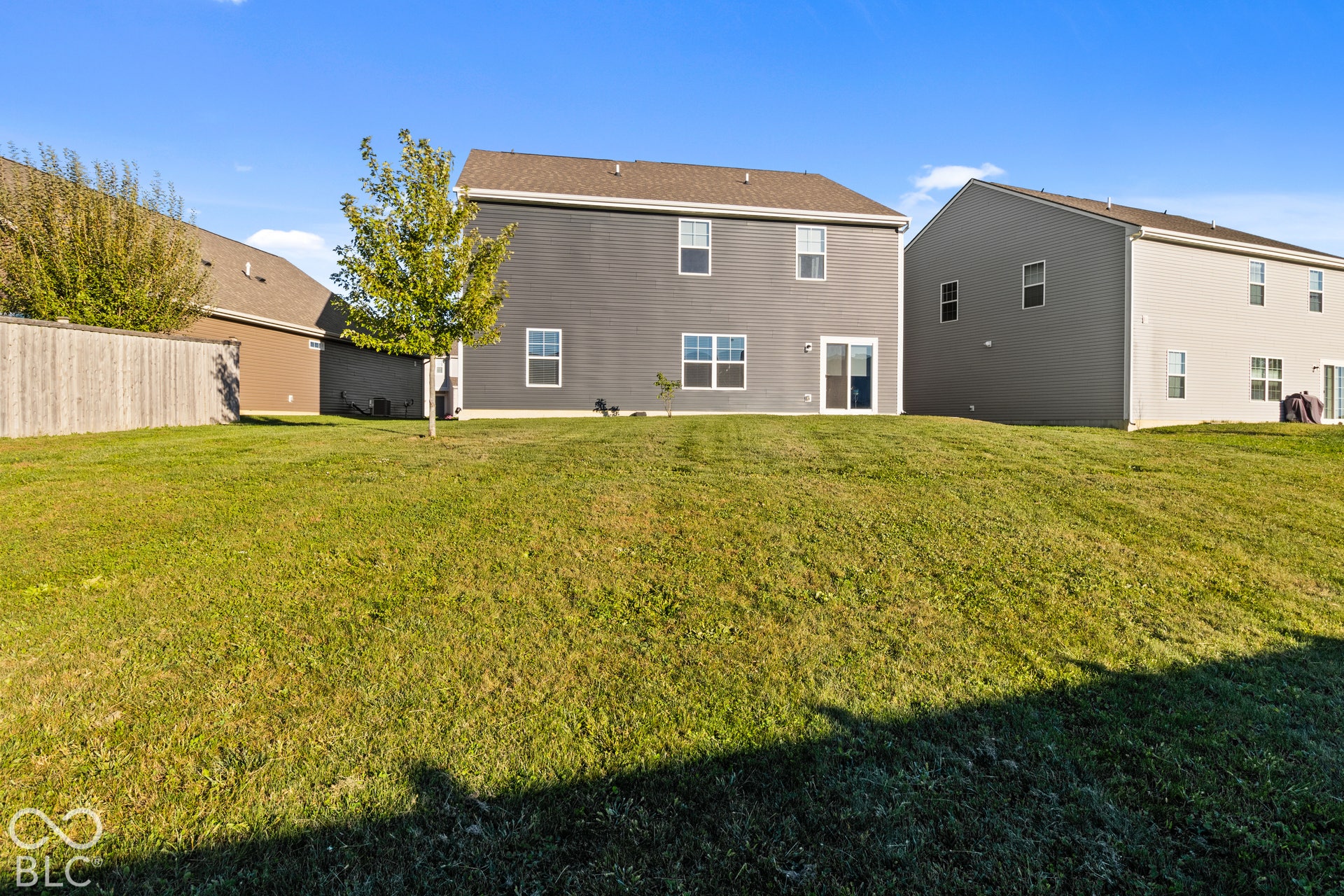 Expansive rear yard featuring green lawn