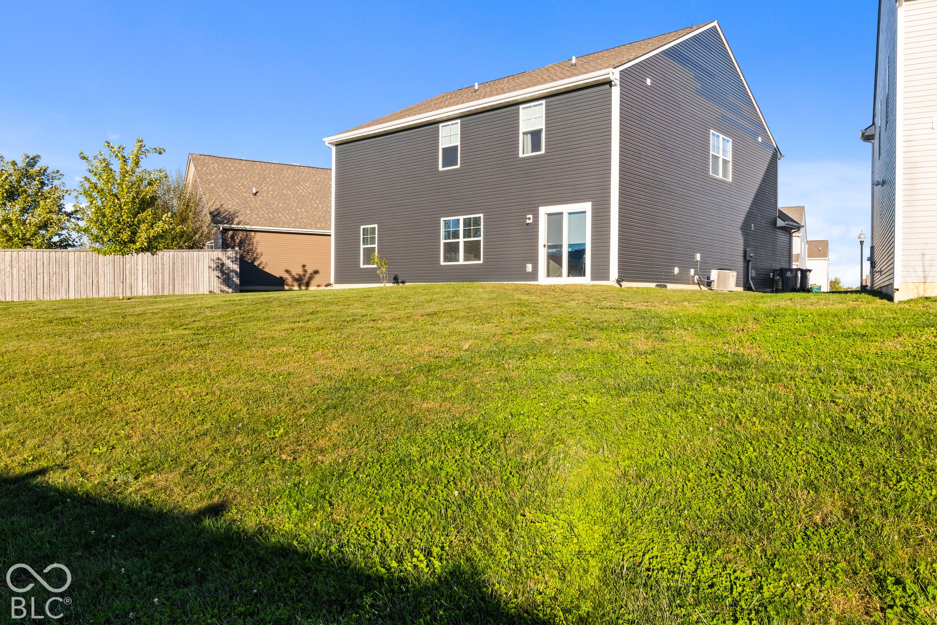Expansive grassy yard with a privacy fence