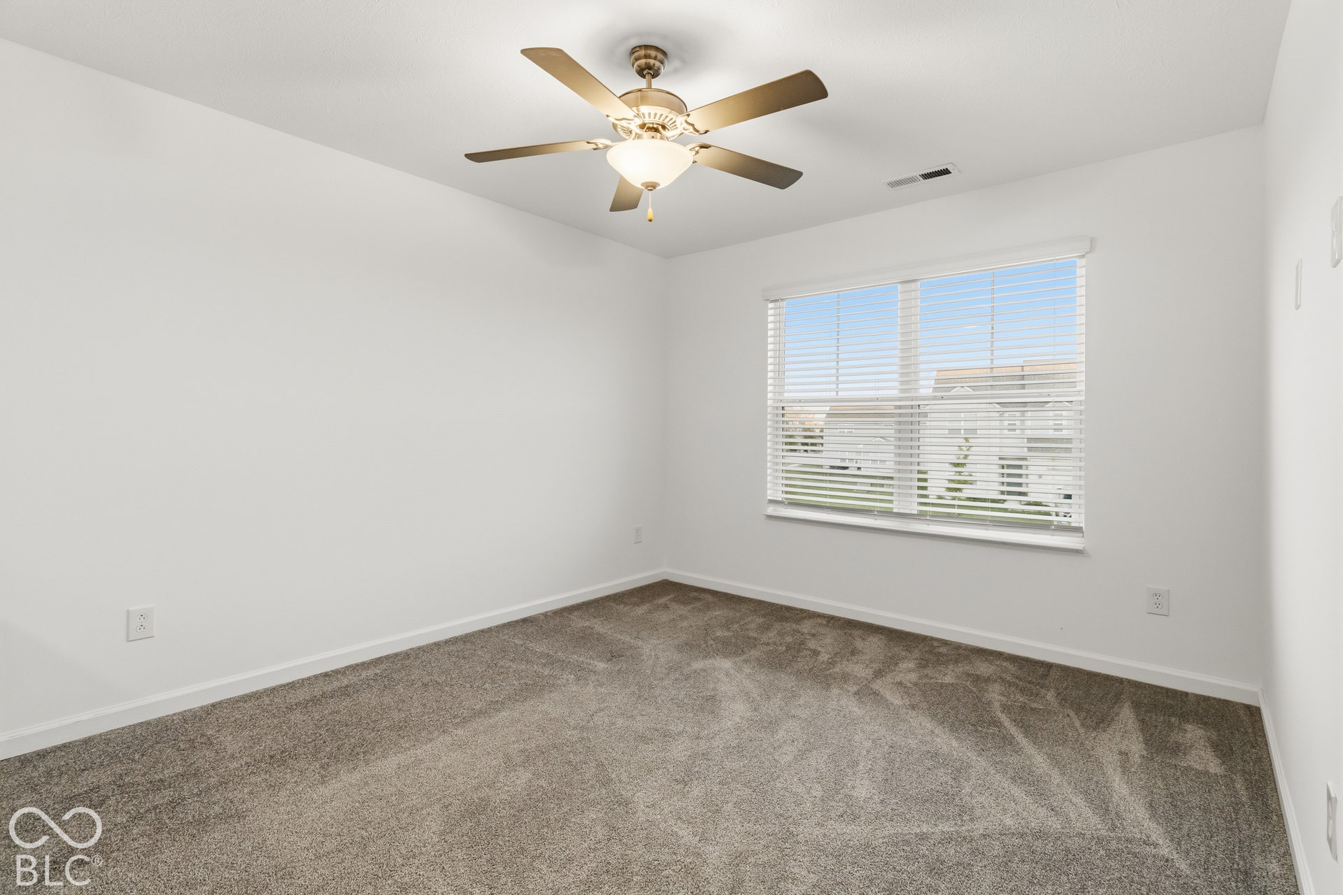Wall-to-wall carpeting and a ceiling fan with integrated lighting